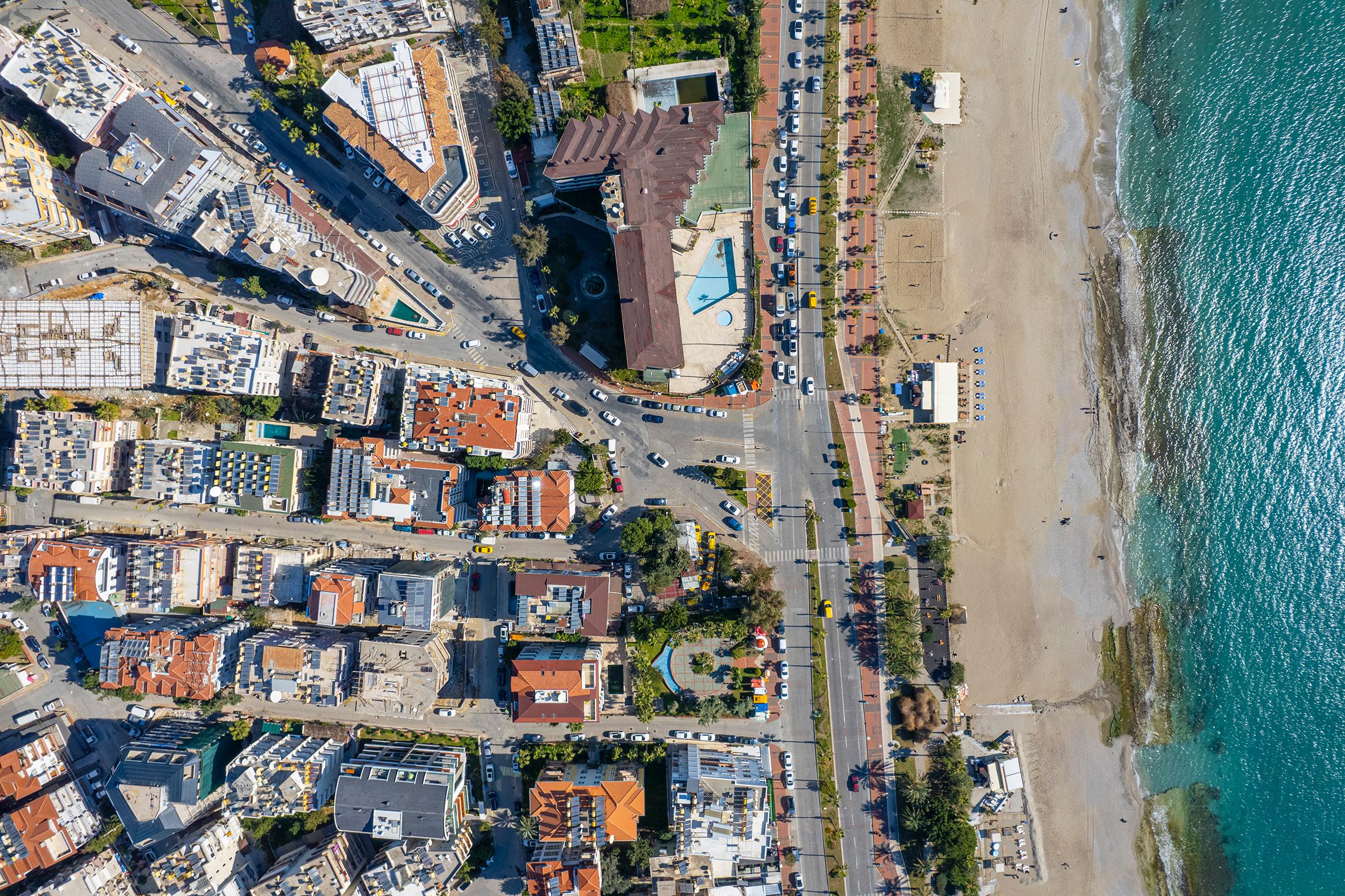 Turkuaz deniz ve kumlu kent plajı boyunca, Türkiye’de satılık dairelerin yer aldığı yoğun yerleşim