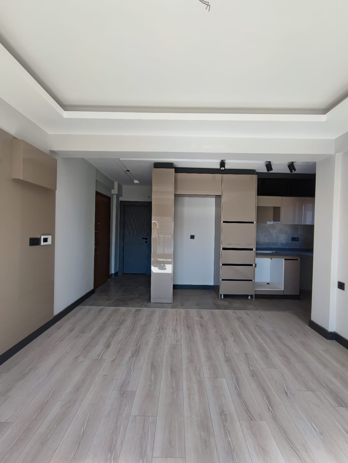 Kitchen-living room with beige and graphite cabinetry in a 1+1 apartment for sale in Turkey