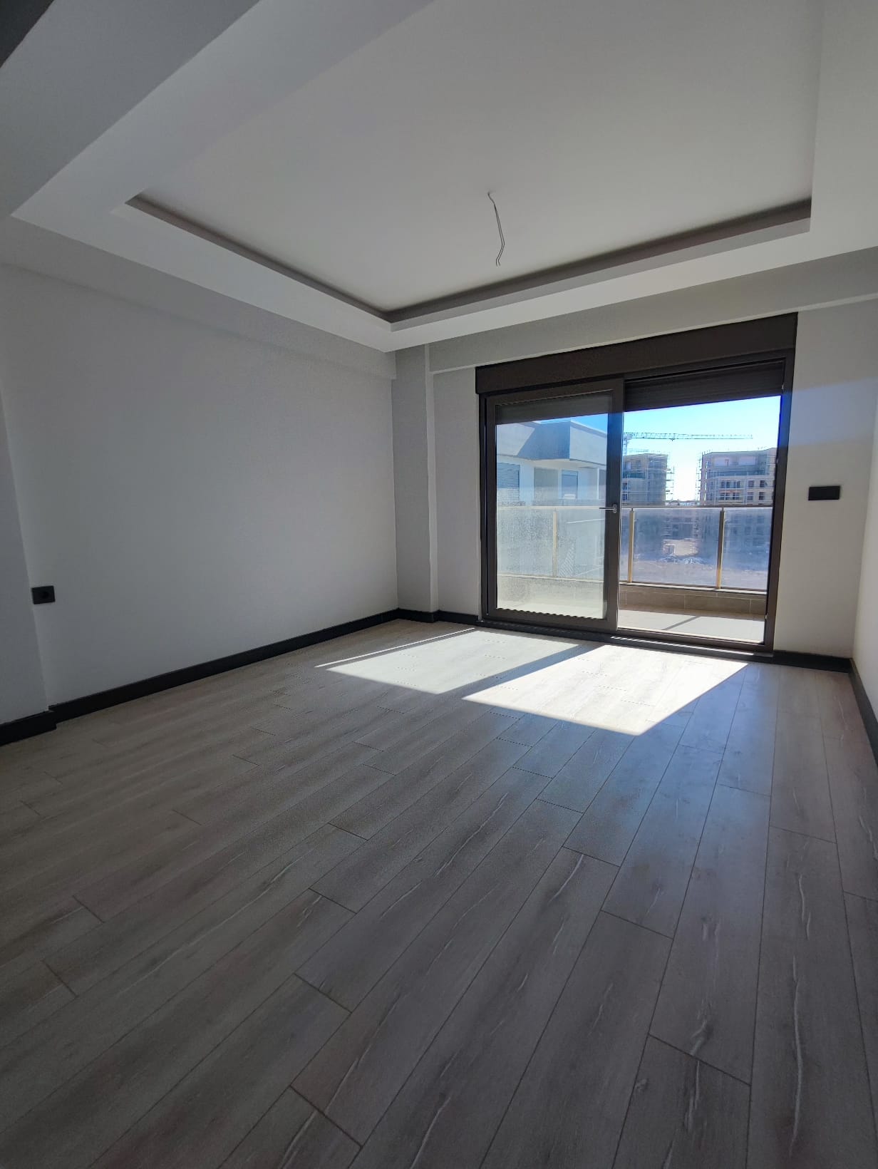Sunlit living room in an apartment in Altyntaş with panoramic glazing and balcony doors
