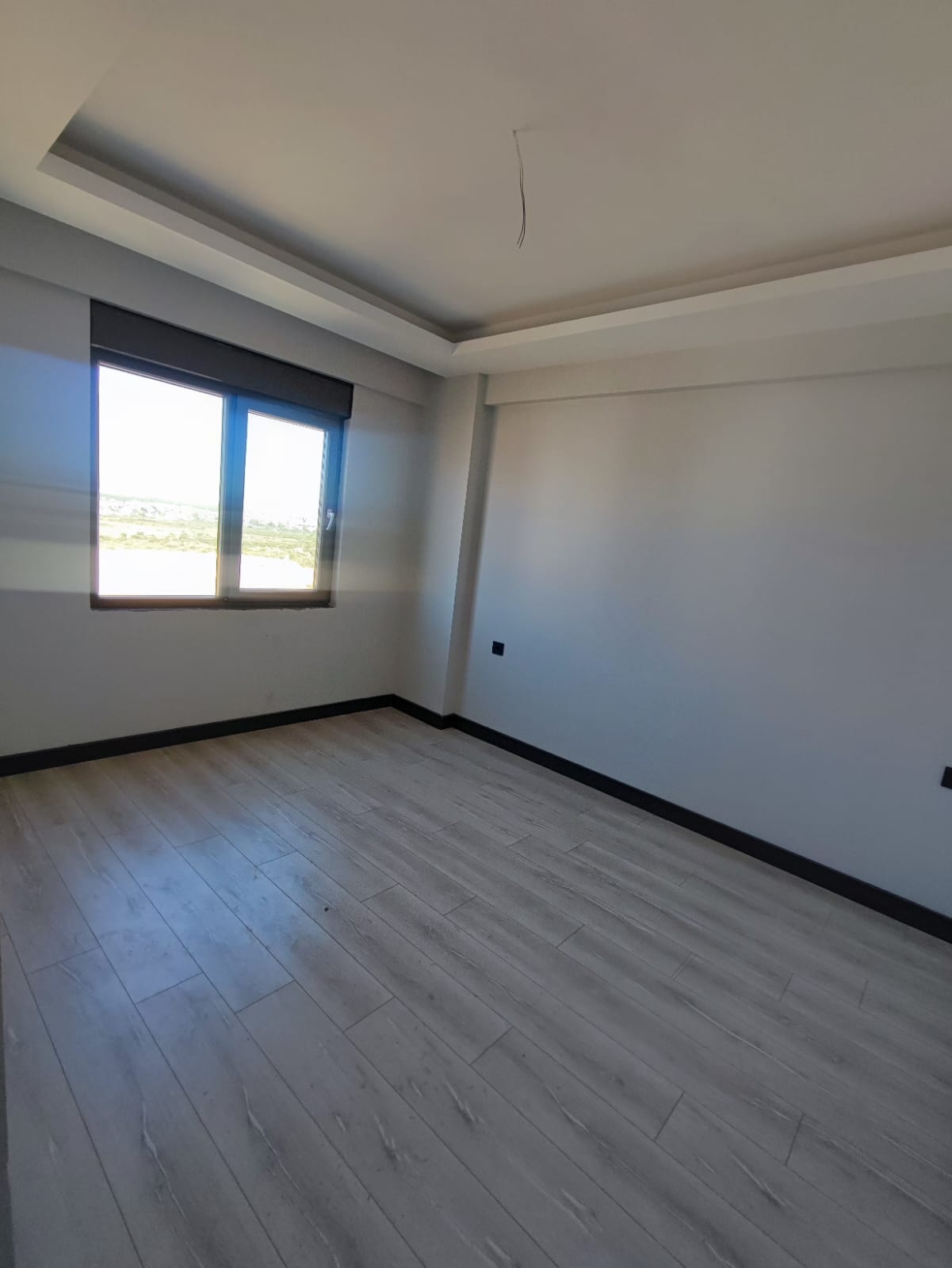 Unfurnished room in an apartment with wood-look laminate and a double casement window
