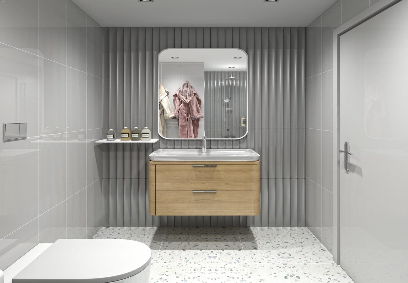 Banyoda iki çekmeceli ahşap lavabo dolabı, yuvarlatılmış aynası ve cam duş bölmesi