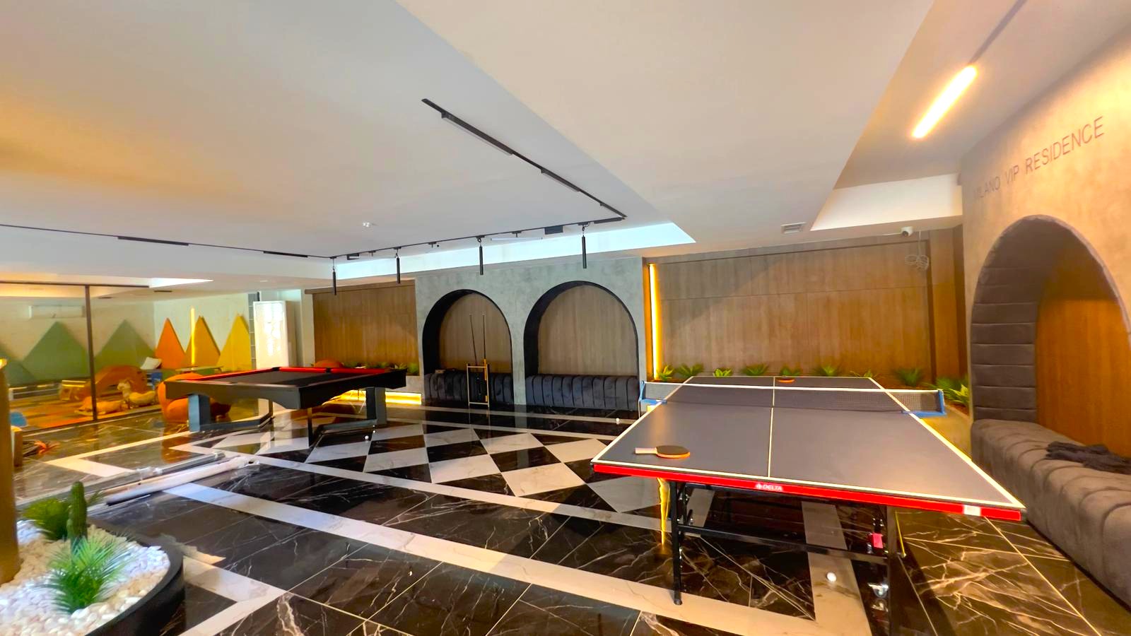Alanya’daki daire sakinleri için bilardo odasında tenis masası, kemerli nişte gri kanepe ve desenli zemin
