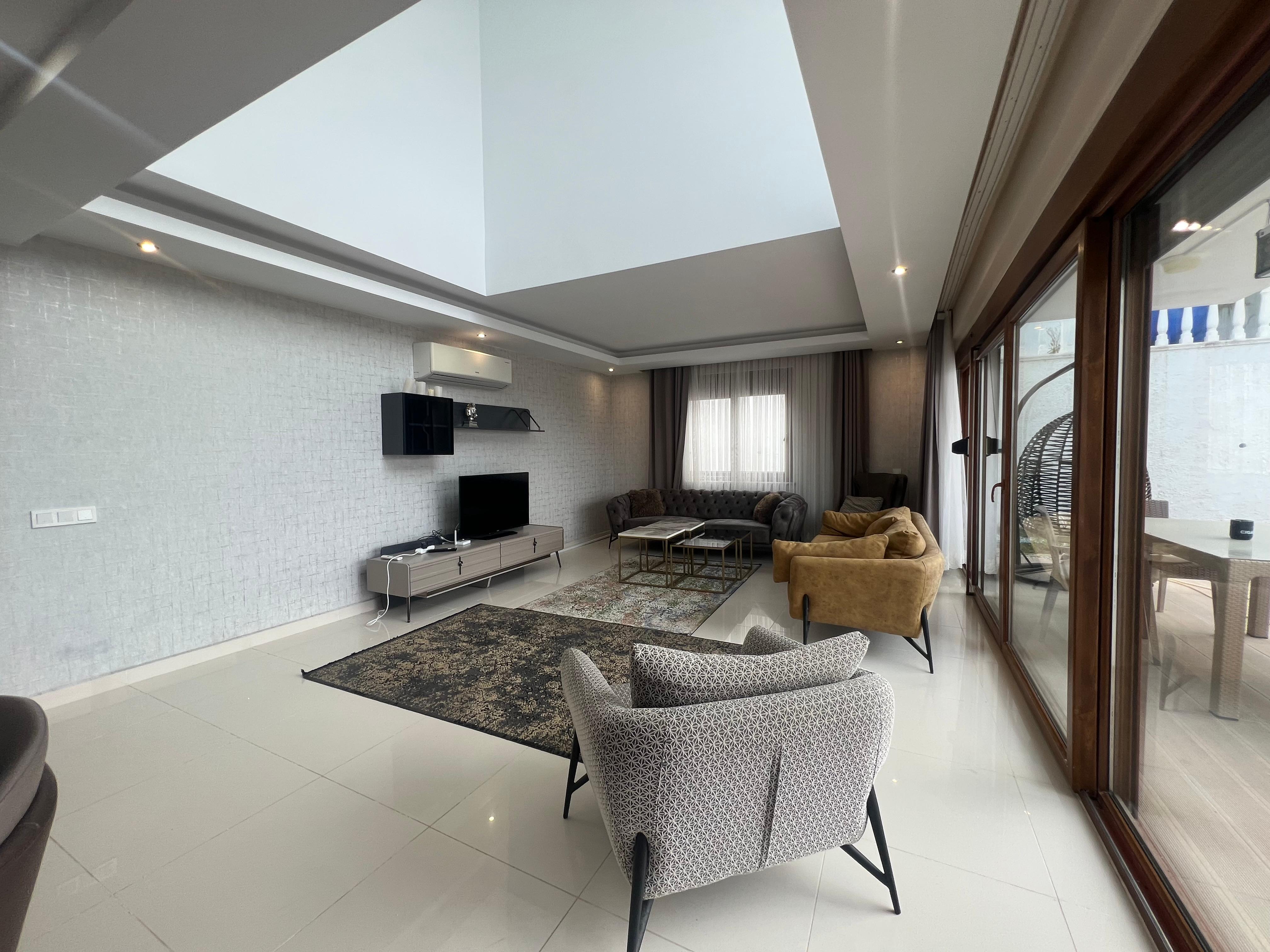 Living room with a brown sofa and sliding glazing in a house for sale in Kargicak
