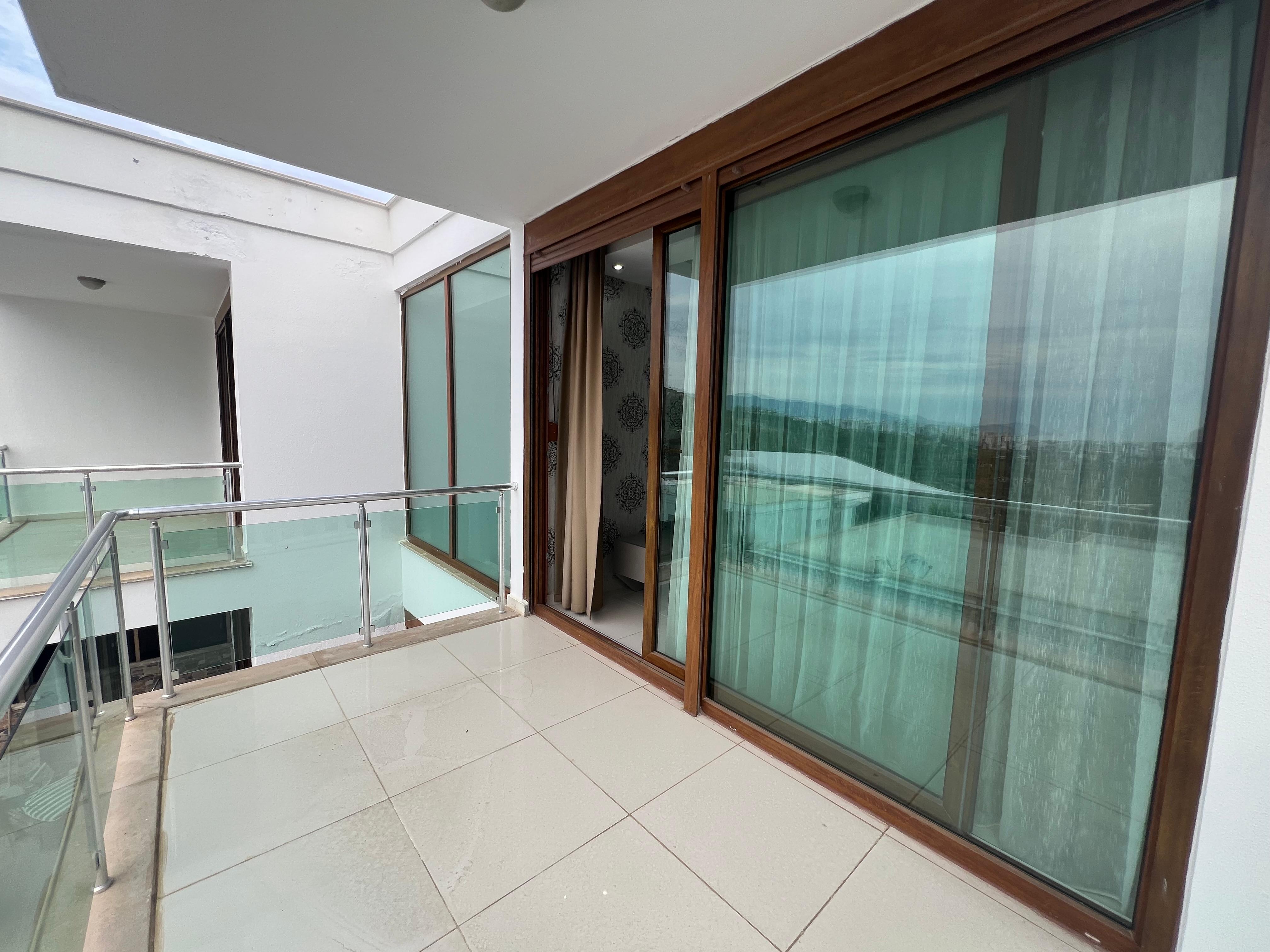 Spacious terrace with panoramic sliding glass doors at a villa for sale in Kargicak