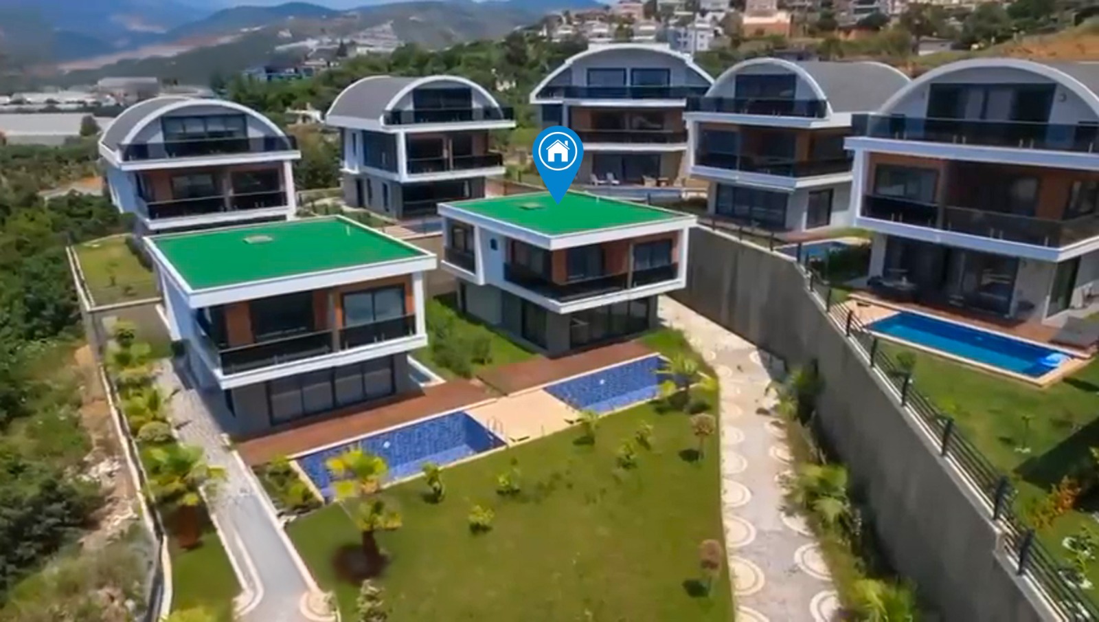 Aerial view of detached villas with private pools and mountains in Turkey where villas are for sale