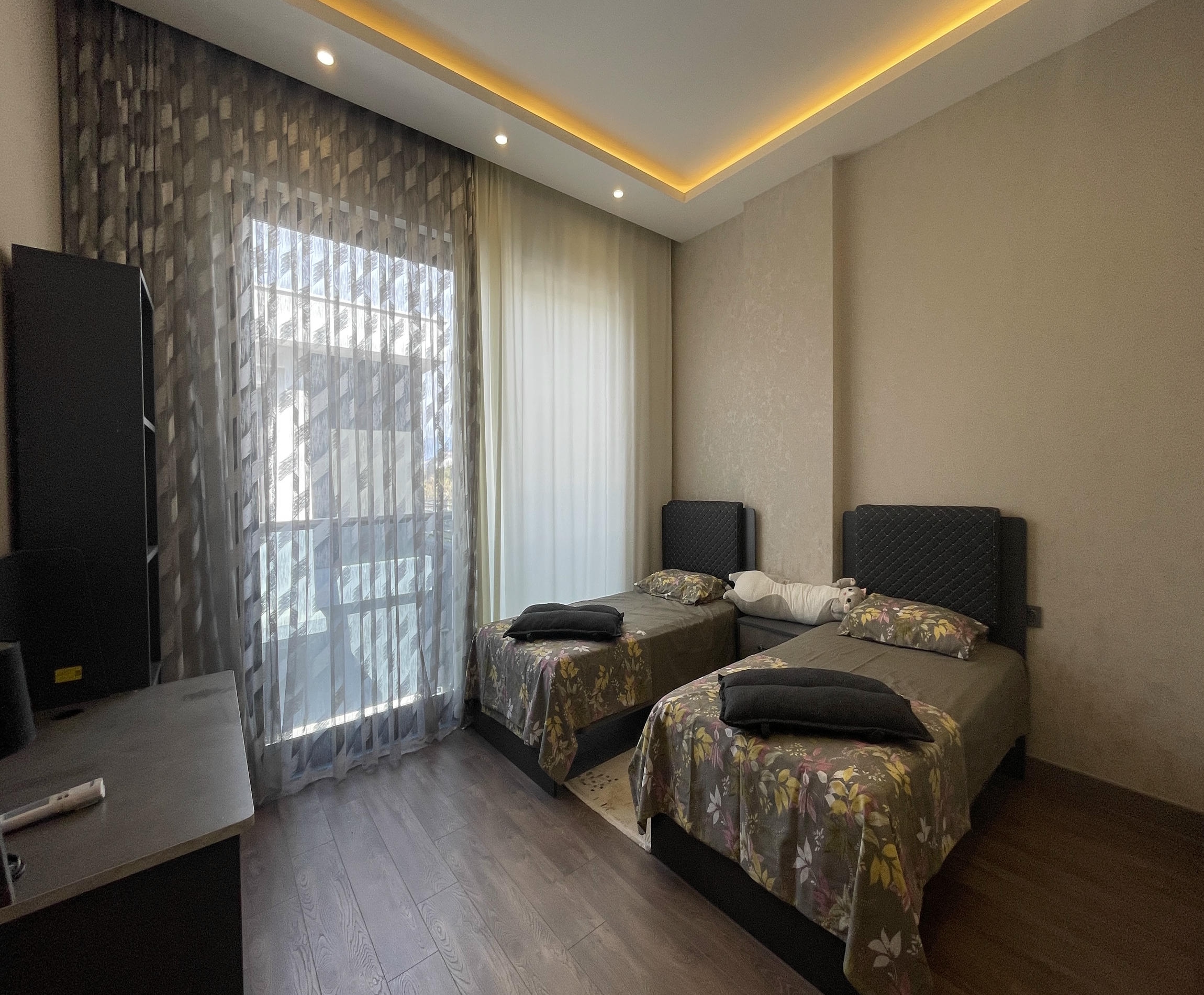 İki tek kişilik yataklı yatak odasında dokulu vurgulu duvar ve panoramik pencere villa içinde