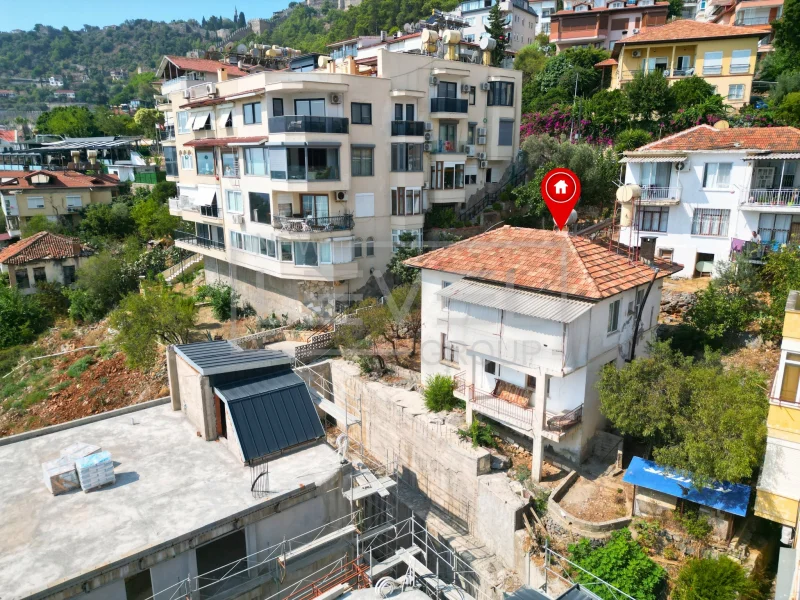 A red-tiled villa among hillside homes with retaining walls in Alanya, Turkey for sale — New Level Group