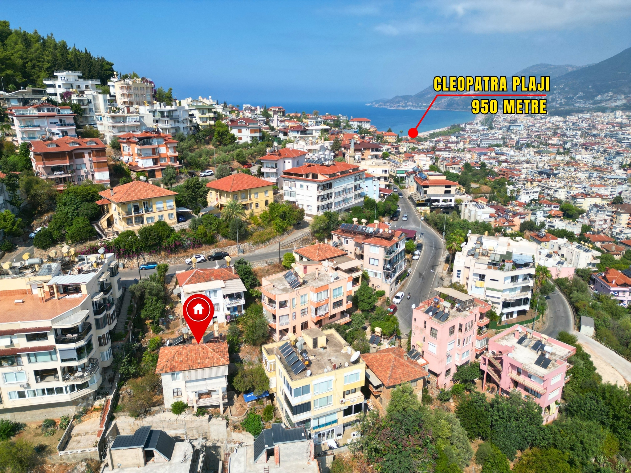 Dense urban streets with green spaces and a sea horizon across Alanya