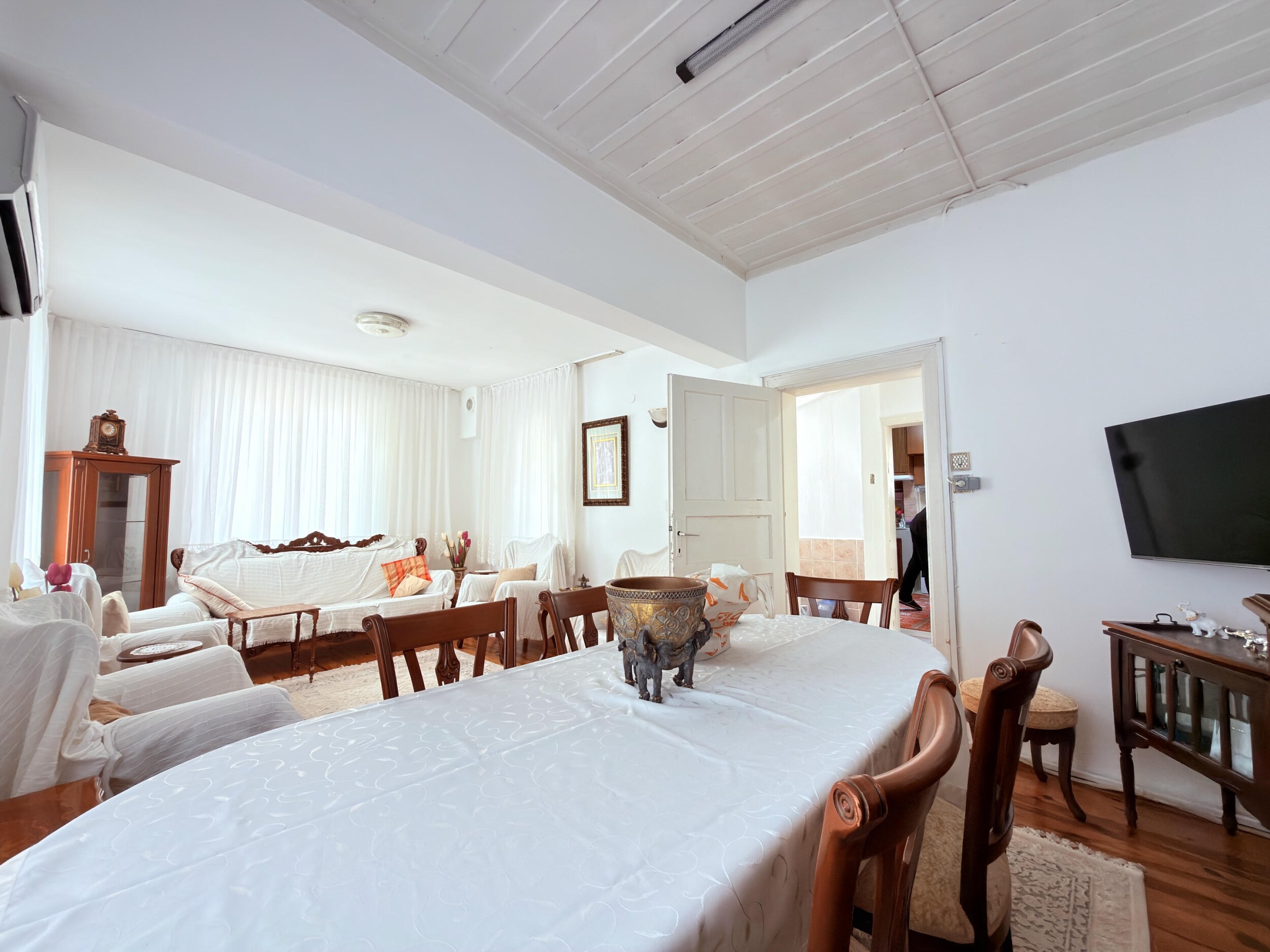 A dining area with carved wooden chairs beside a covered seating area in an Alanya villa, Turkey
