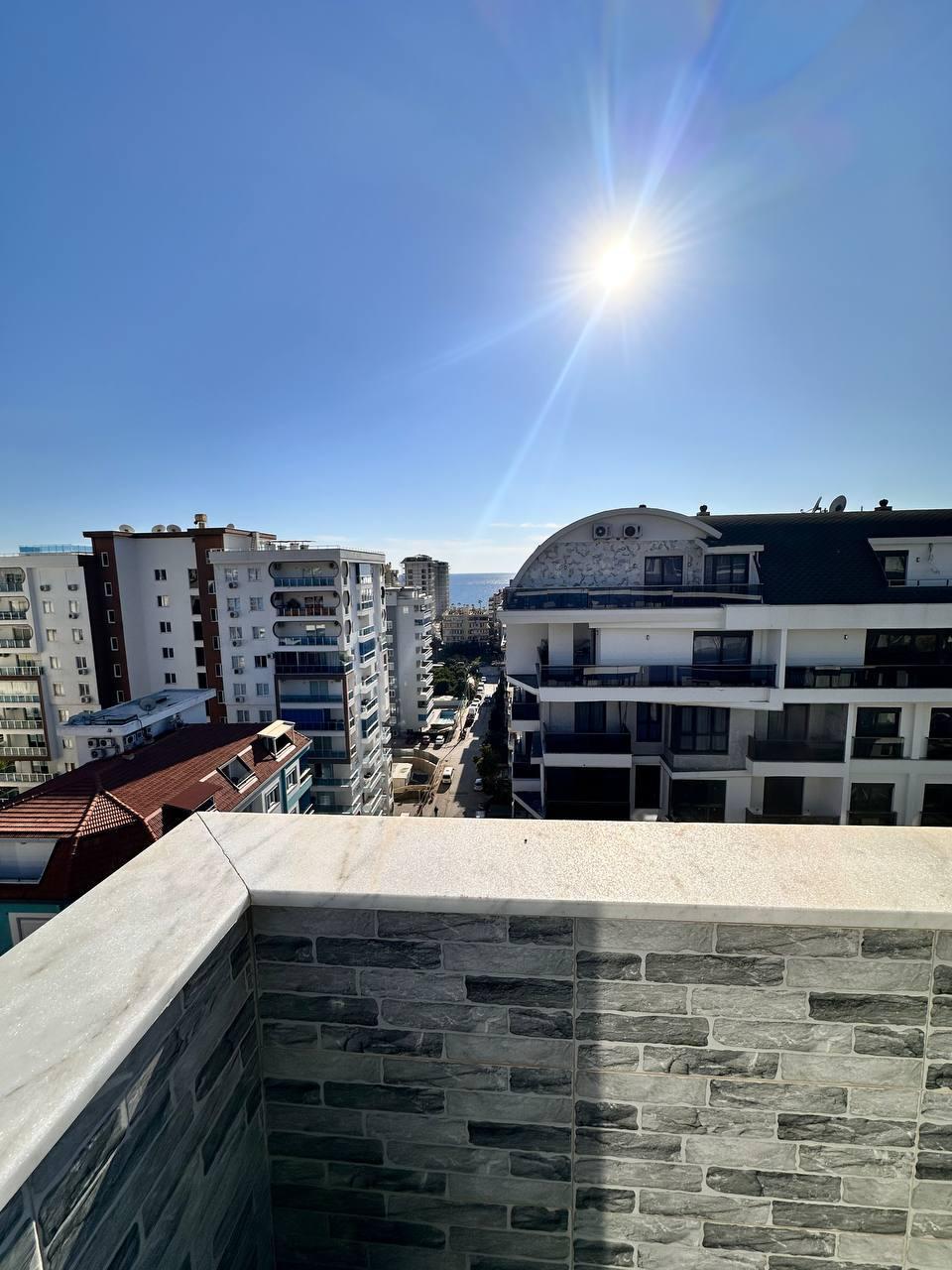 Köşe teras, Türkiye’de satışta olan penthouse çevresinde deniz ve binalar arasındaki şehir sokağı manzarasıyla