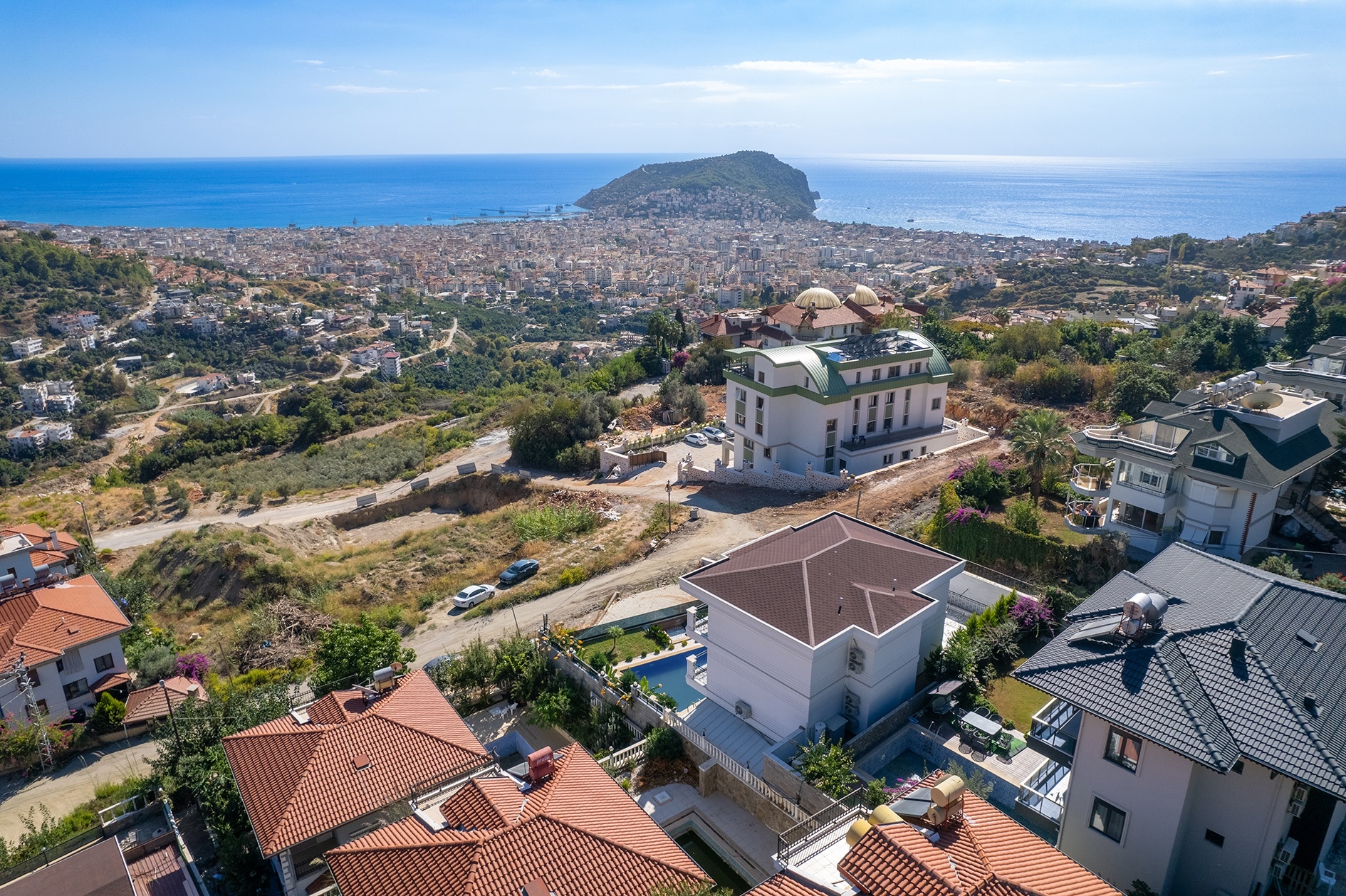 Coastal panorama with an island, green hills and villas among winding roads in Turkey for sale