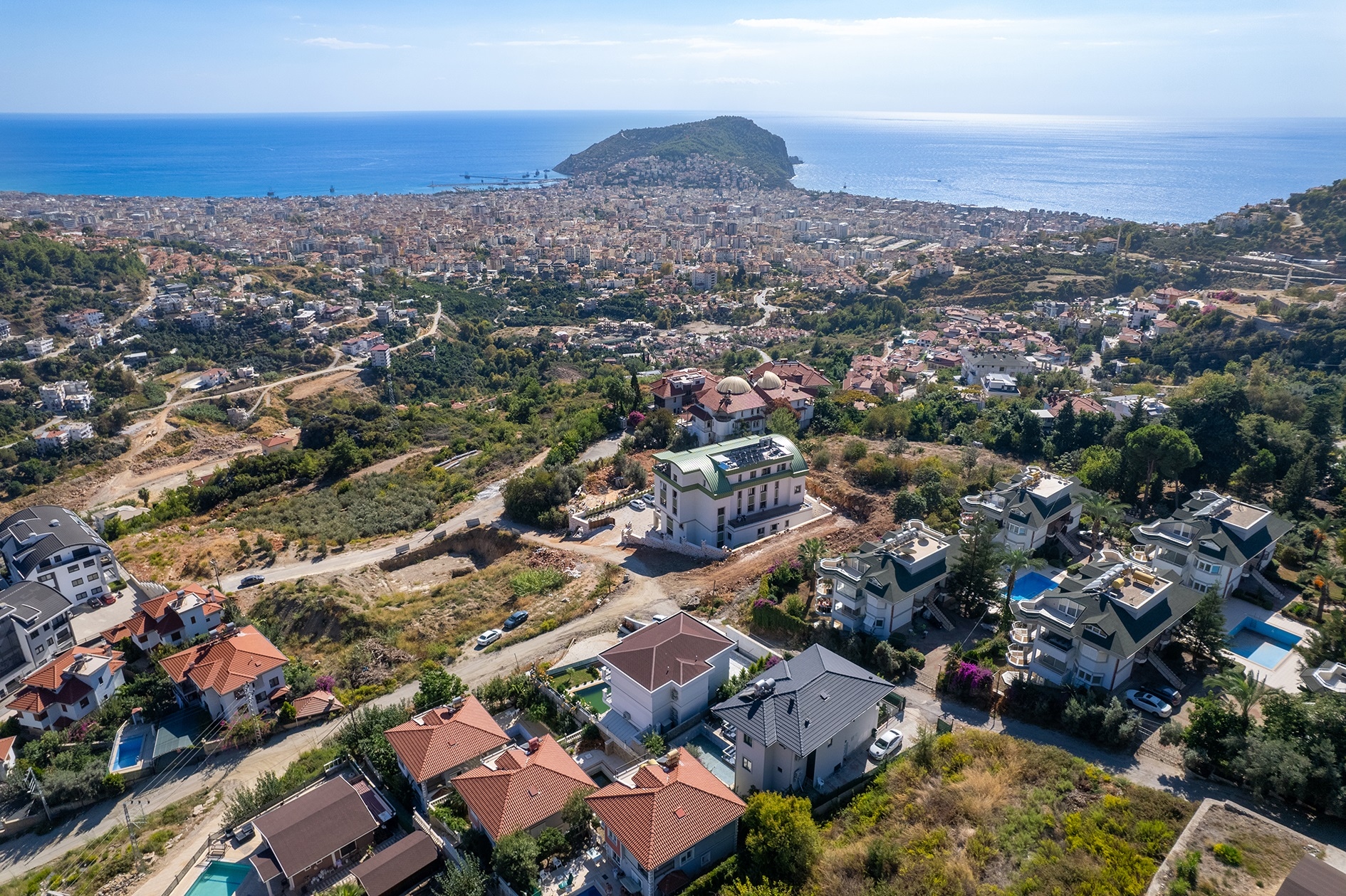 Wide city and coastal view with private villas, pools and a sea horizon in Alanya, Turkey