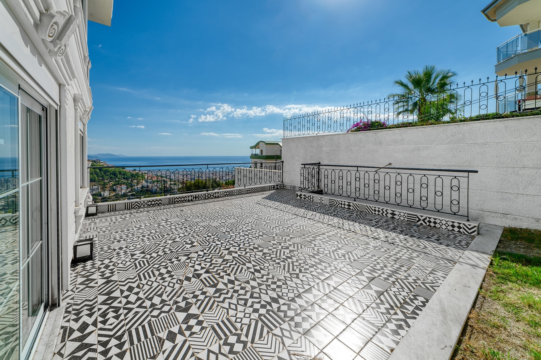 Terrace with a panoramic glass door and sea view between neighboring villas in Alanya for sale