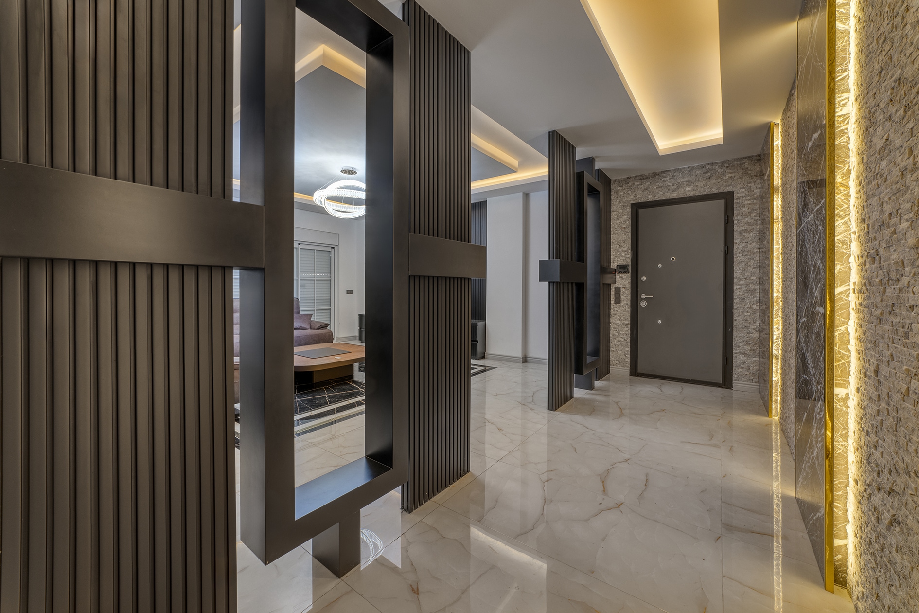 Bright villa hall with marble flooring, slatted partitions and a dark entrance door in Alanya