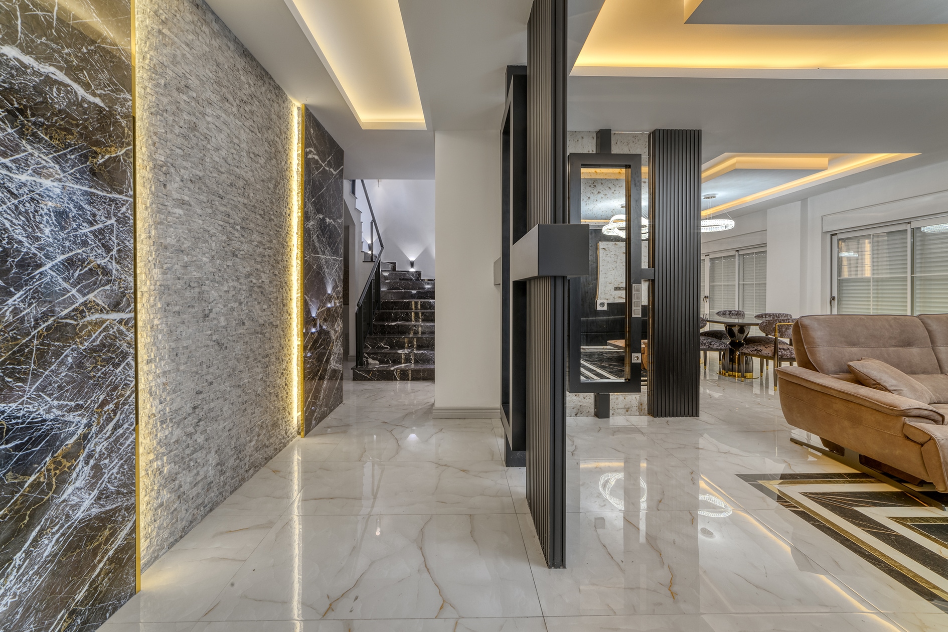 Bright hall with glossy marble flooring, a staircase and a dining area in Alanya