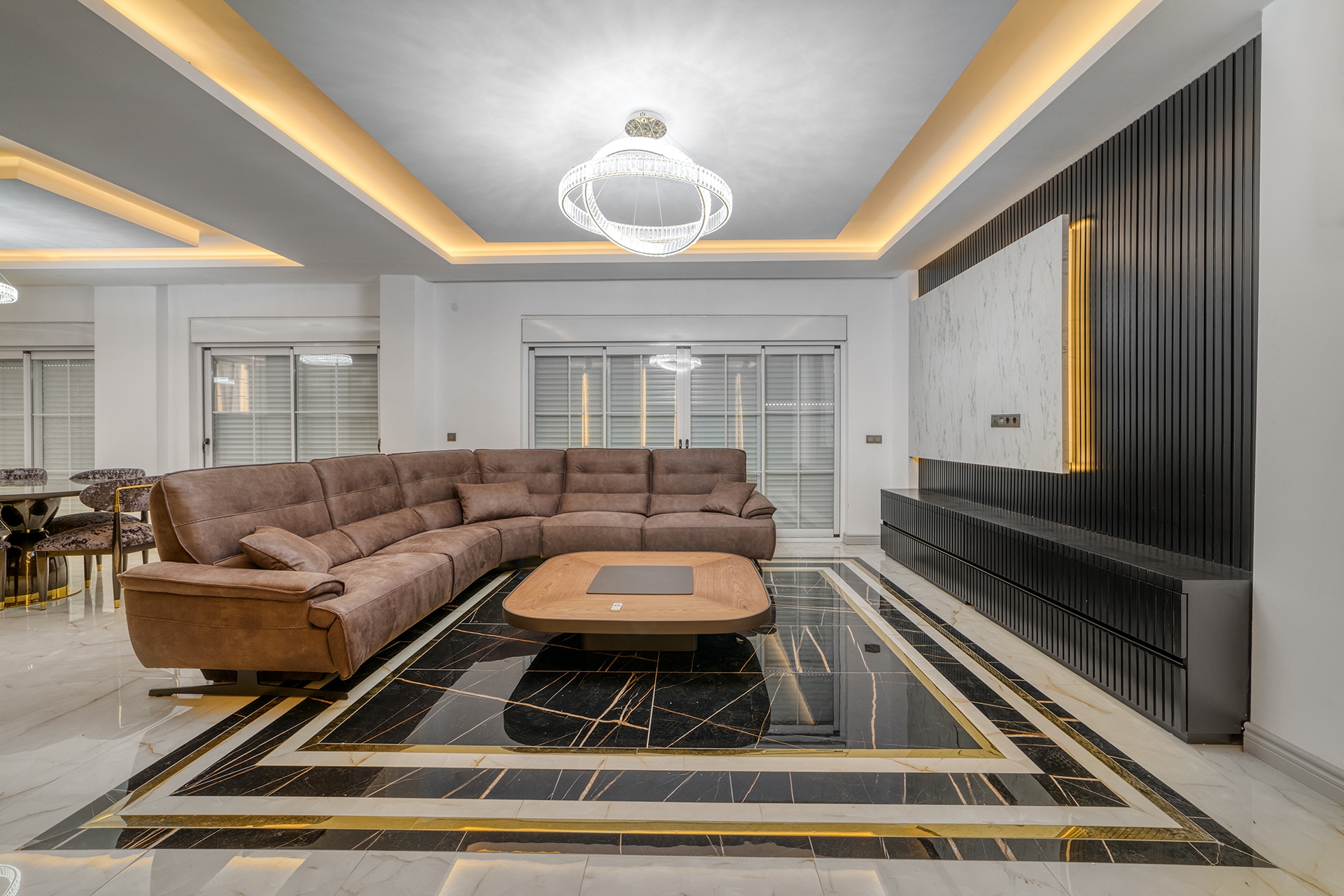 Villa living room with a brown sofa, television cabinet and panoramic windows in Alanya for sale