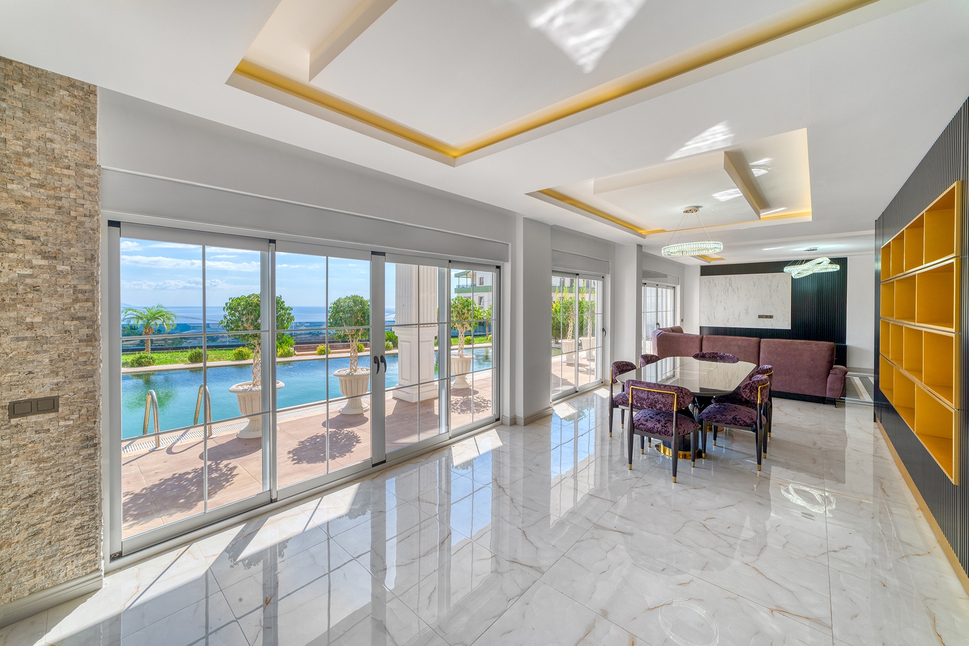 Villa living room with a sofa, dining area, pool and sea view in Turkey for sale