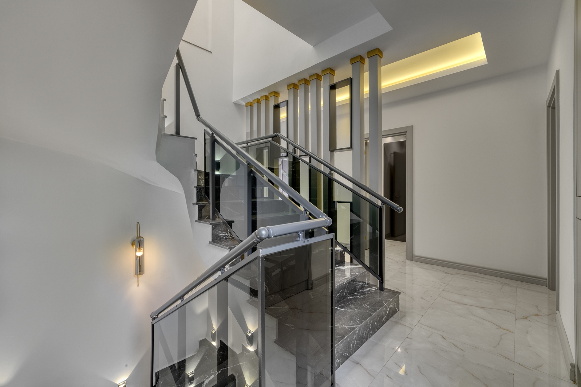 Interior villa staircase with black marble steps and glass railings in Alanya