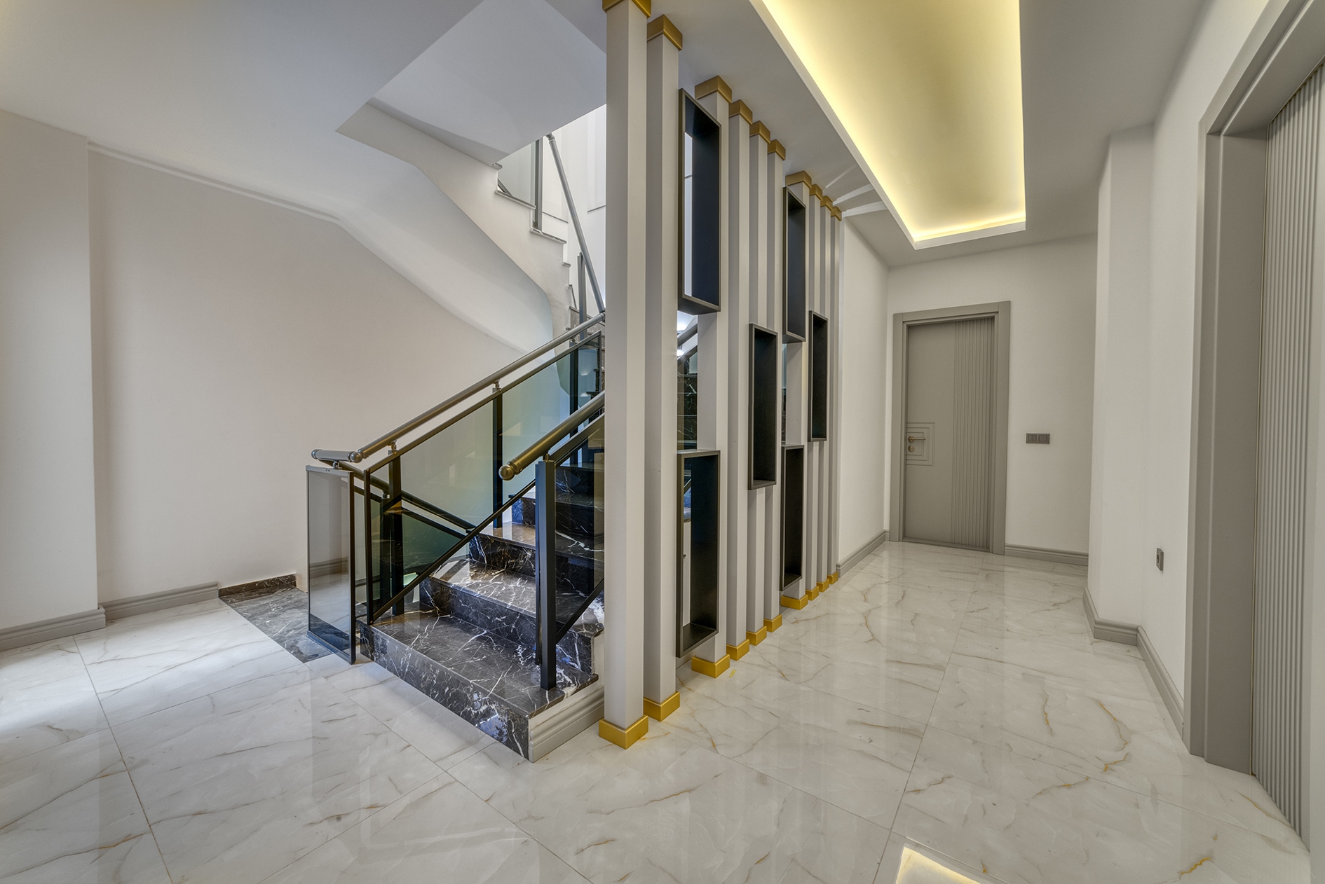 House hall with a stairwell, black marble steps and vertical decorative columns