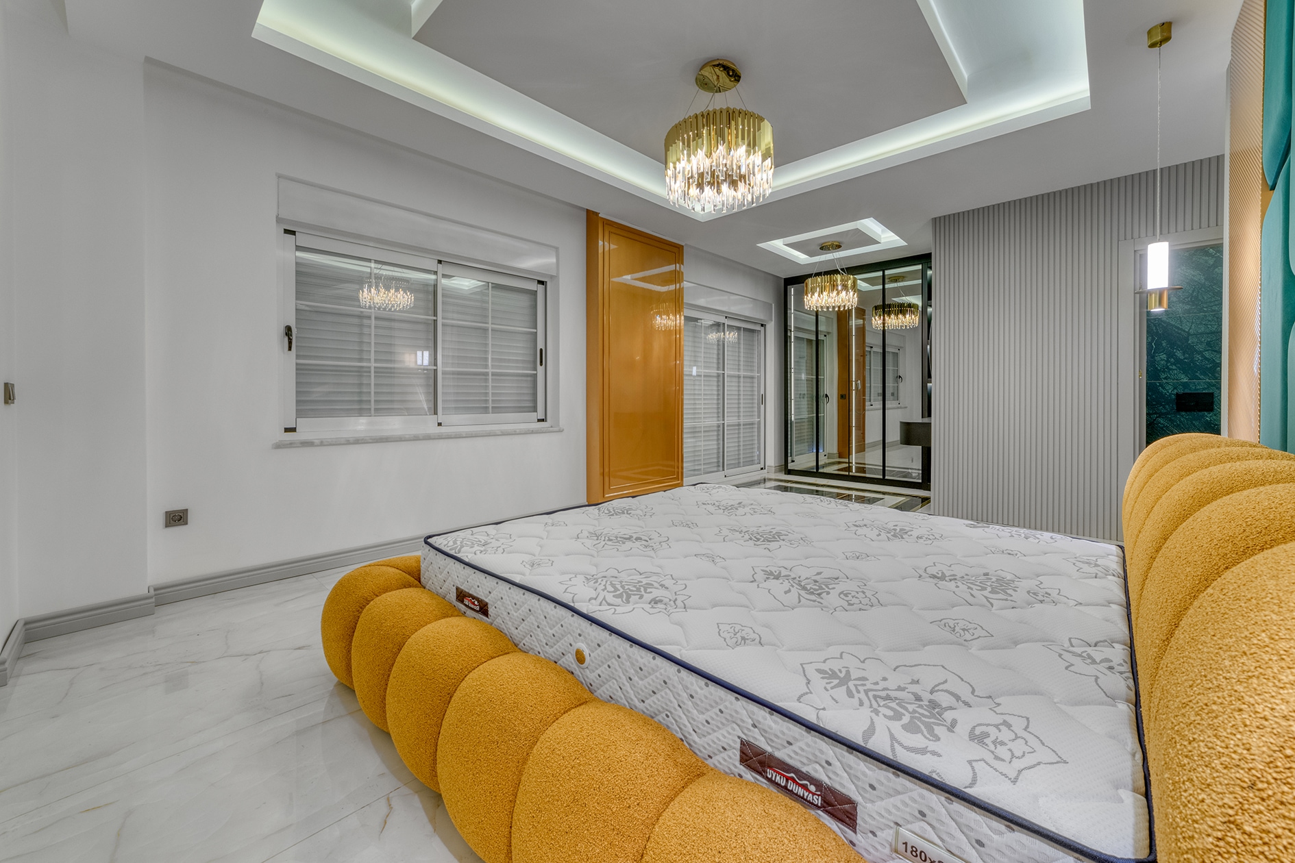 Bedroom with an orange bed, mirrored wardrobe and grey wall panels