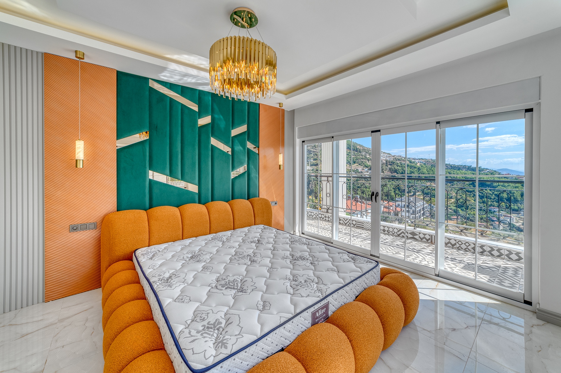 Bedroom with an orange bed, panoramic glazing and mountain landscape in Alanya