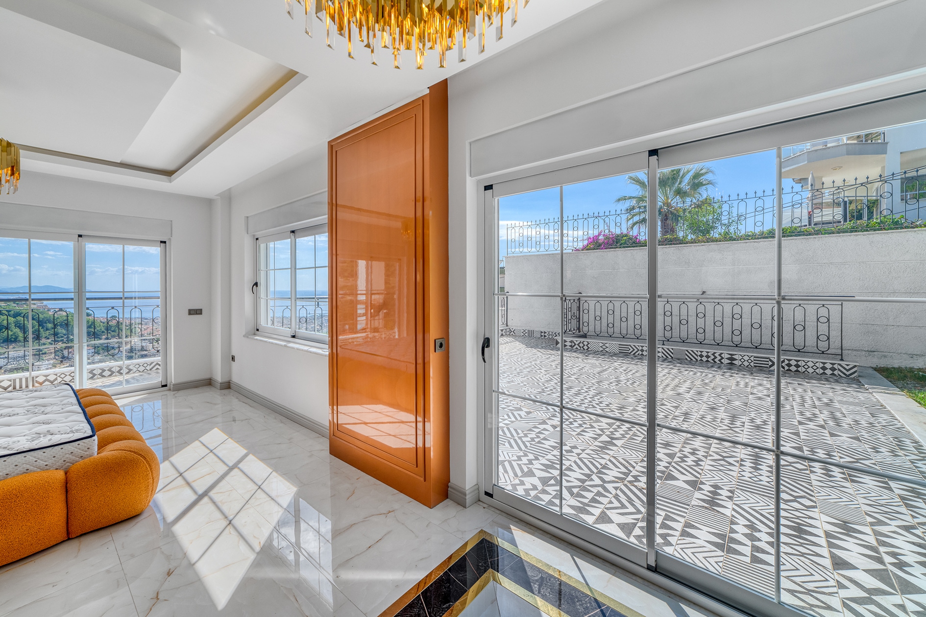 House bedroom with an orange bed, geometric terrace tiles and sea view in Alanya