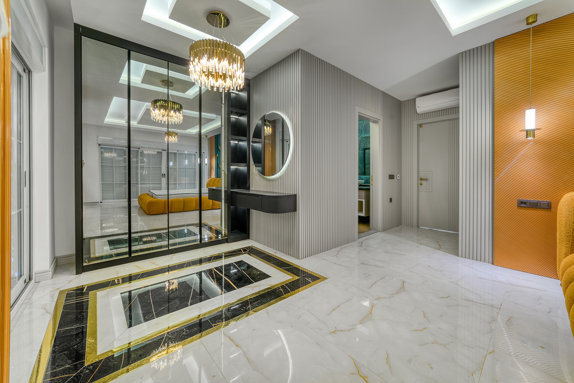 Villa hall with mirrored partition, marble flooring and an orange sofa in reflection in Alanya