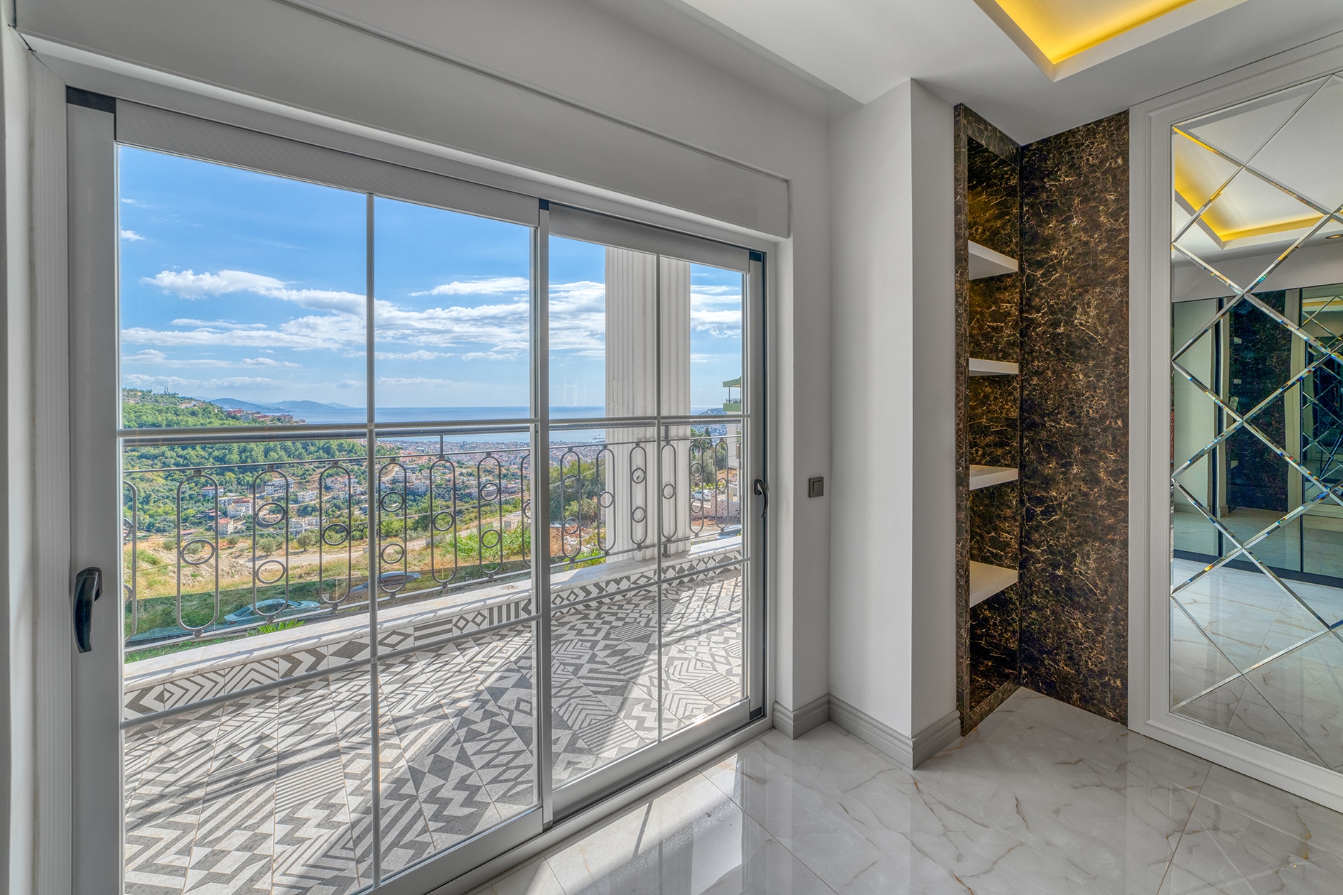 Patterned tiled terrace with sea views and green hills at a villa for sale in Alanya