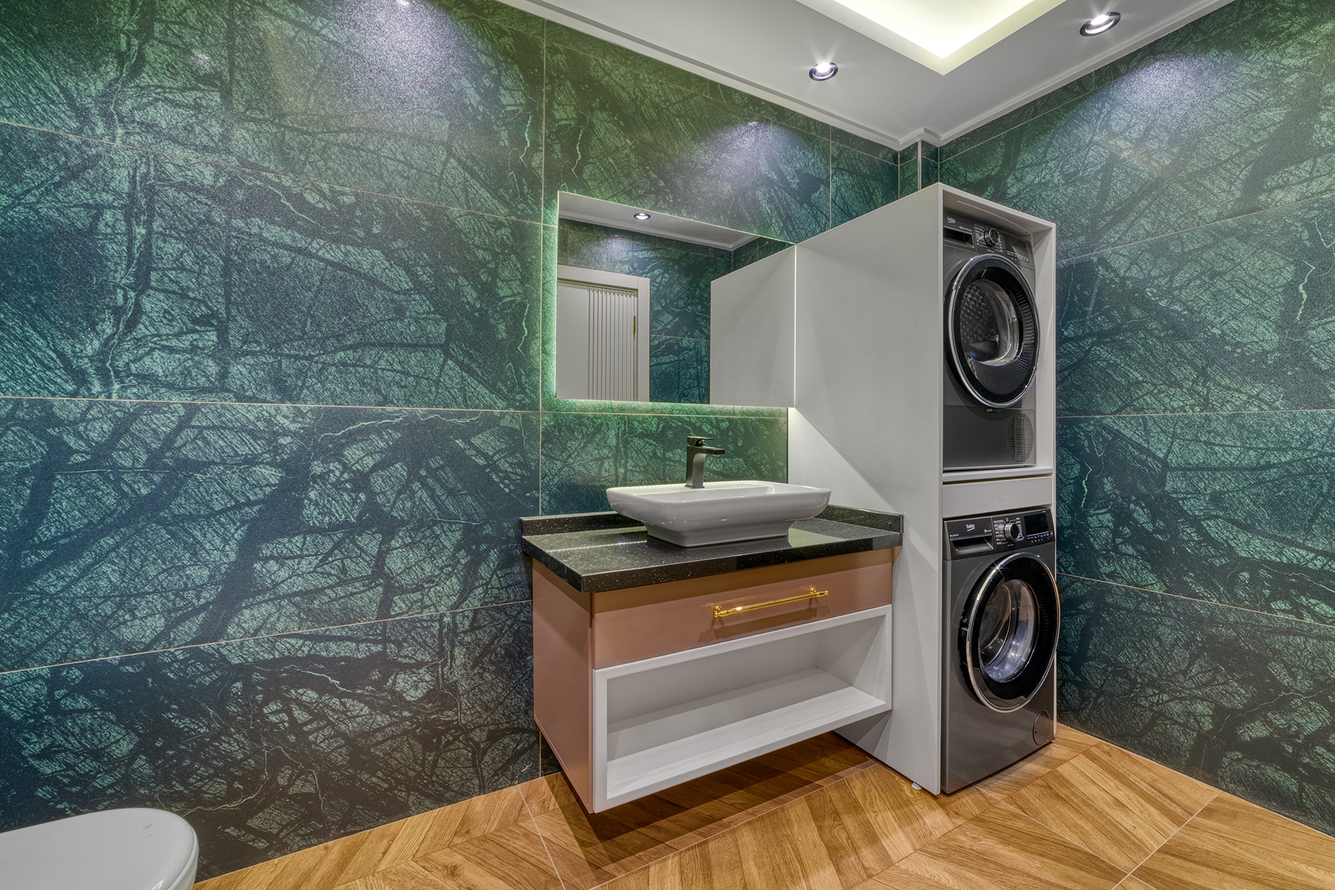 Stacked washer and dryer beside a white basin in Alanya