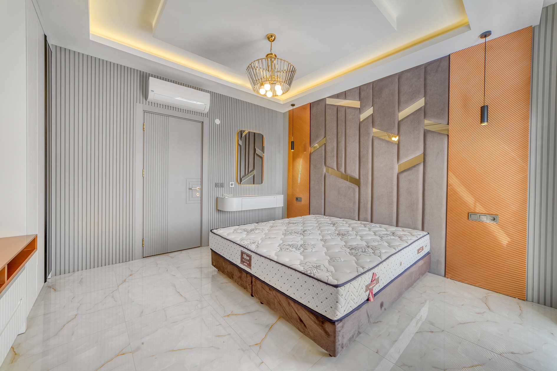 Double bed with orange wall panel and suspended console in a house bedroom in Alanya