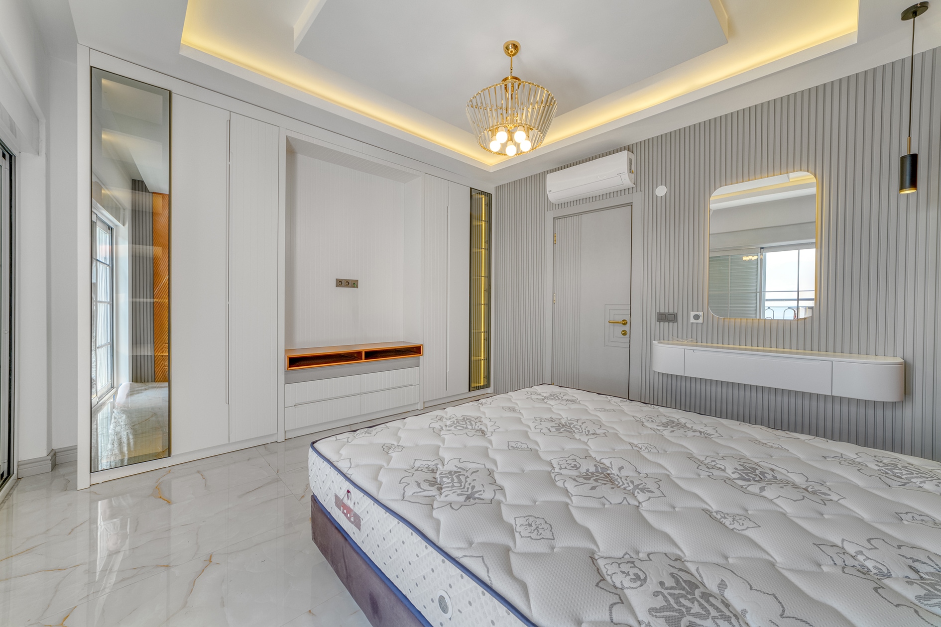 Double bed with mirrored wardrobe and television niche in a bedroom in Alanya