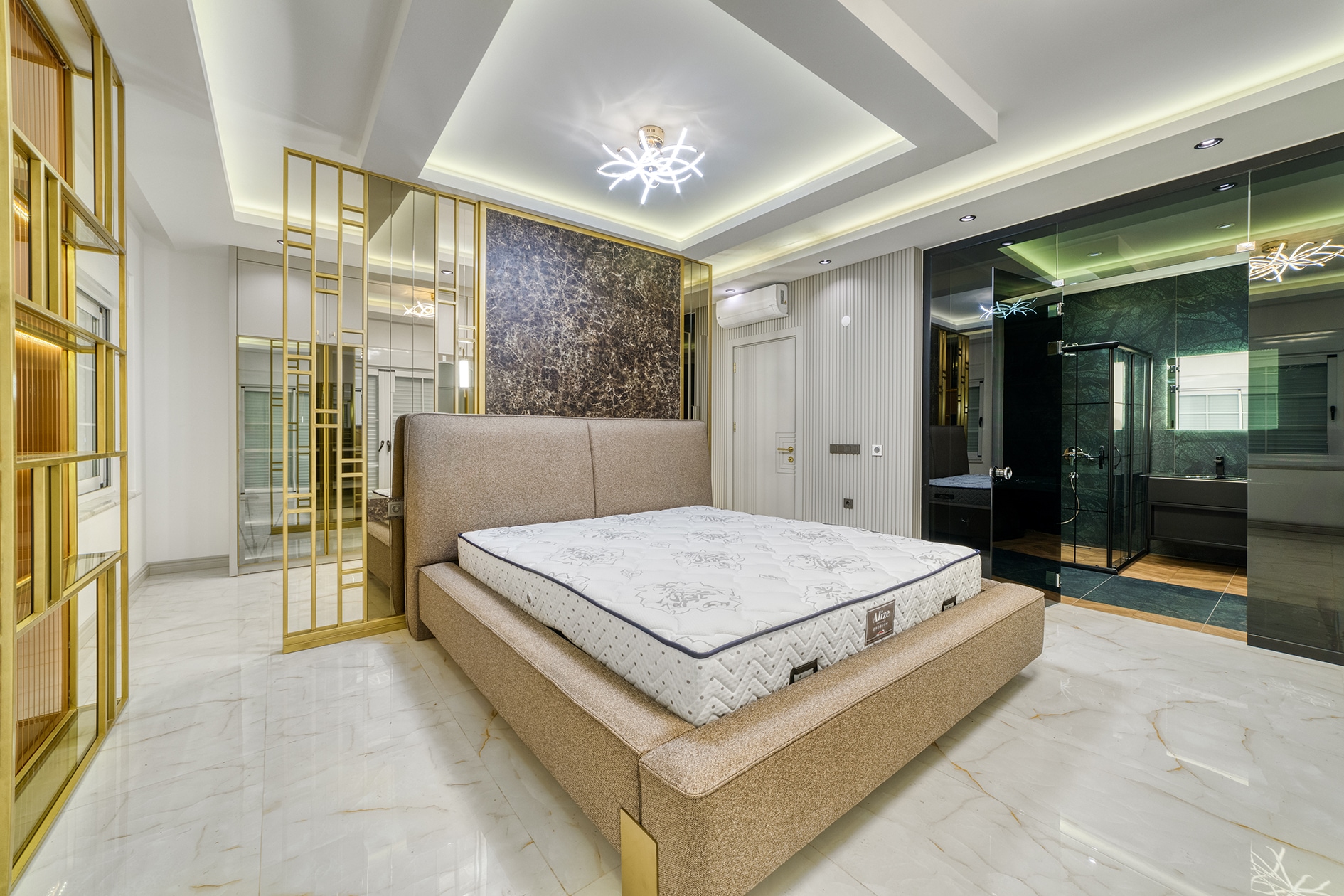 Beige bed with a padded headboard and gold partition in a villa bedroom