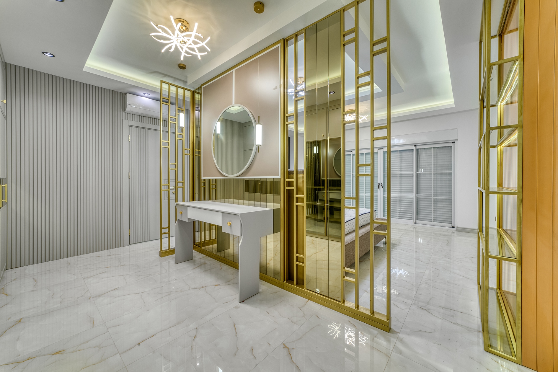 White dressing table beside a gold partition and textured wall panel in a villa bedroom
