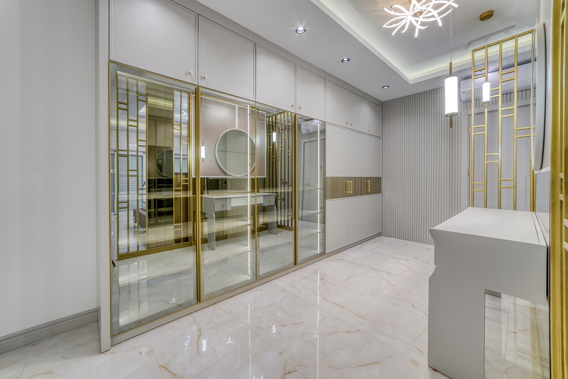 Mirrored partition and built-in wardrobes with gold frames in a bedroom in Alanya