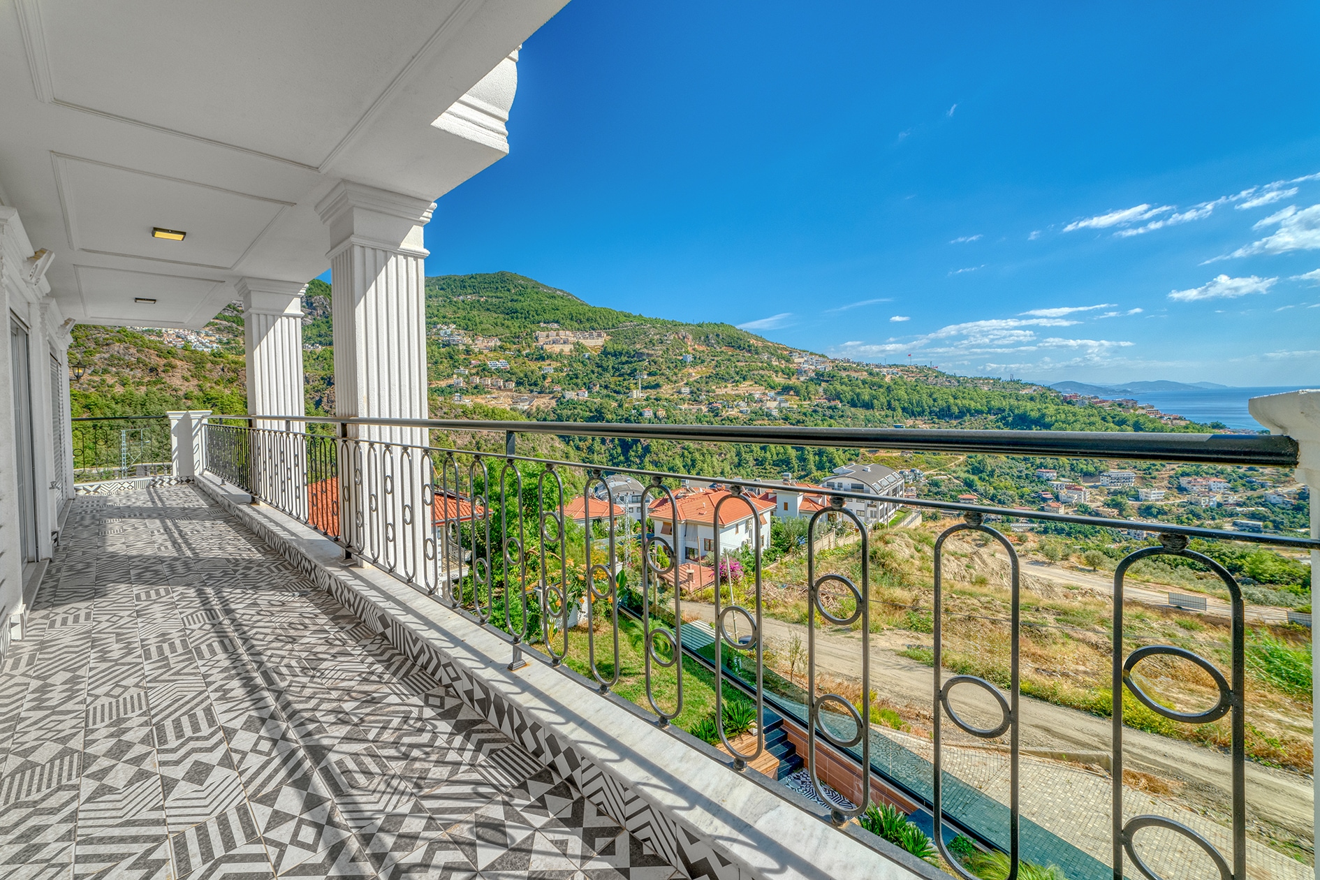 Open terrace with black railings overlooking mountains and city buildings in Turkey
