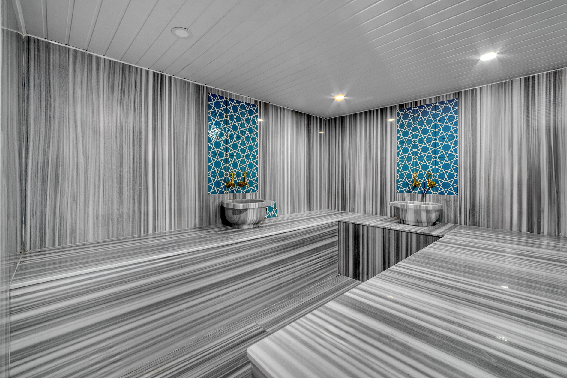 Inside the hammam, a central marble platform and marble bowls feature in a complex with villas in Alanya