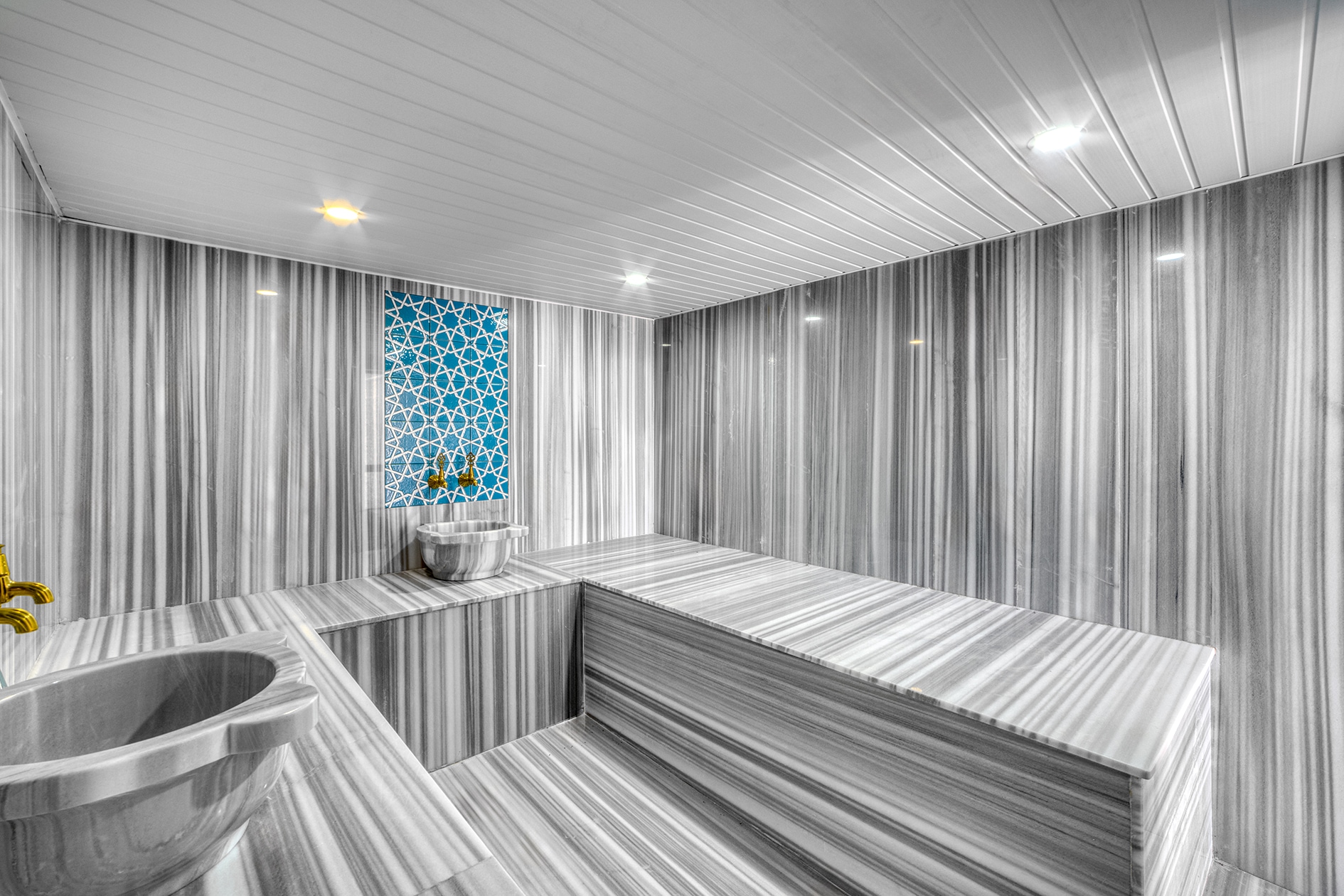 Marble bowl and corner loungers inside the hammam of a complex with villas