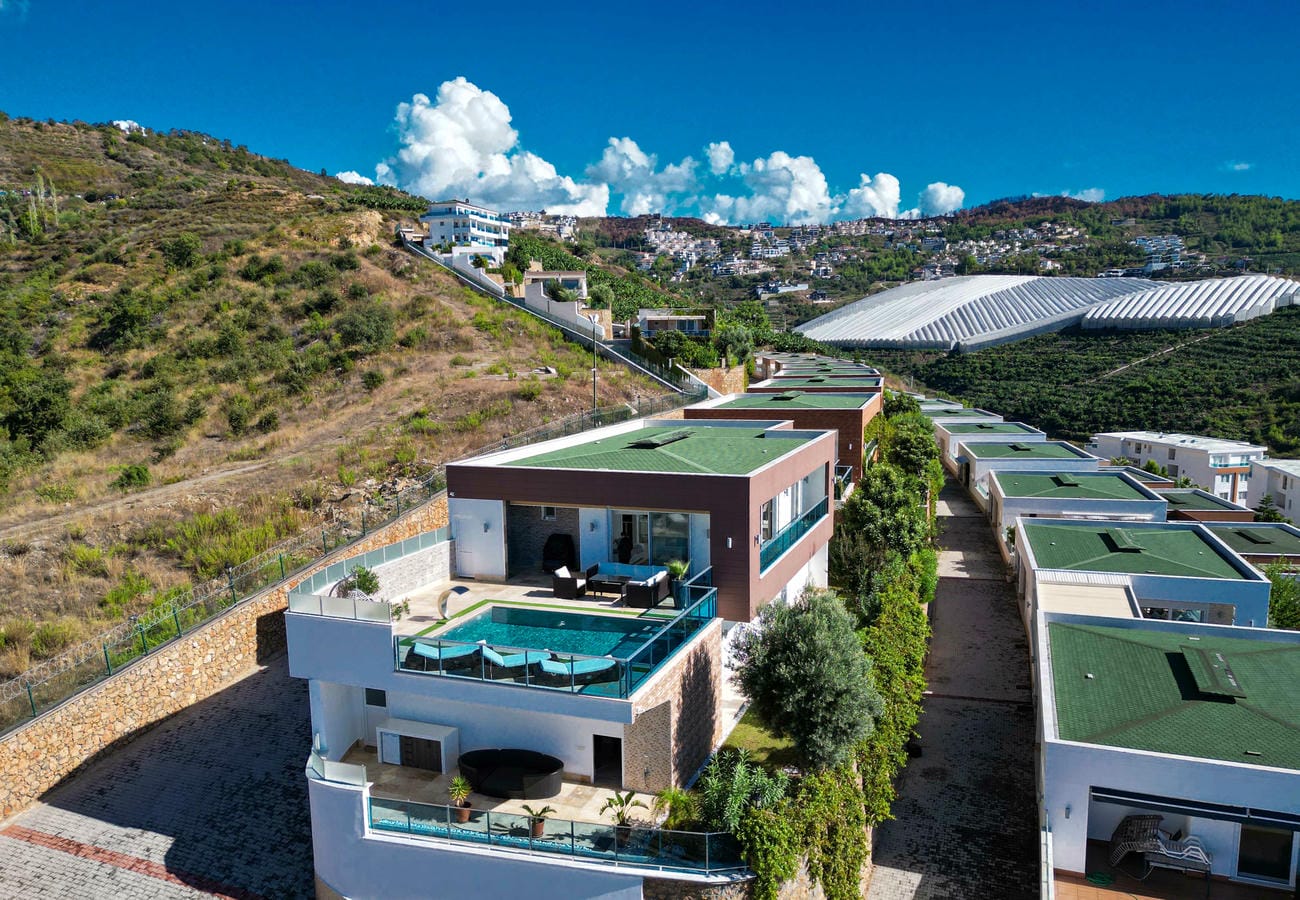 Low-rise villas with a terrace pool and green roofs in Kargicak where villas are for sale
