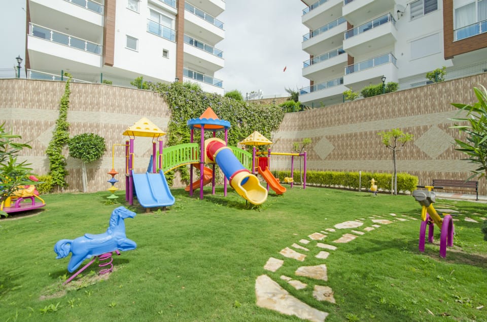 Children’s playground with slides and a colorful tunnel in a complex for villa residents in Kargicak