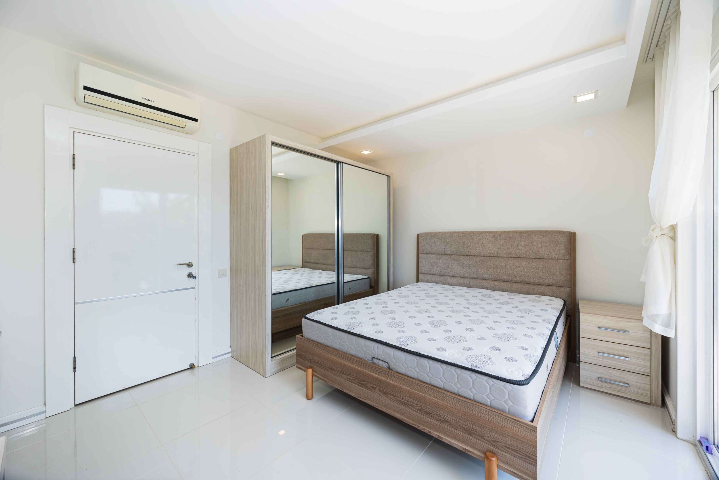 Bedroom with a double bed, mirrored wardrobe and panoramic window in a villa in Kargicak