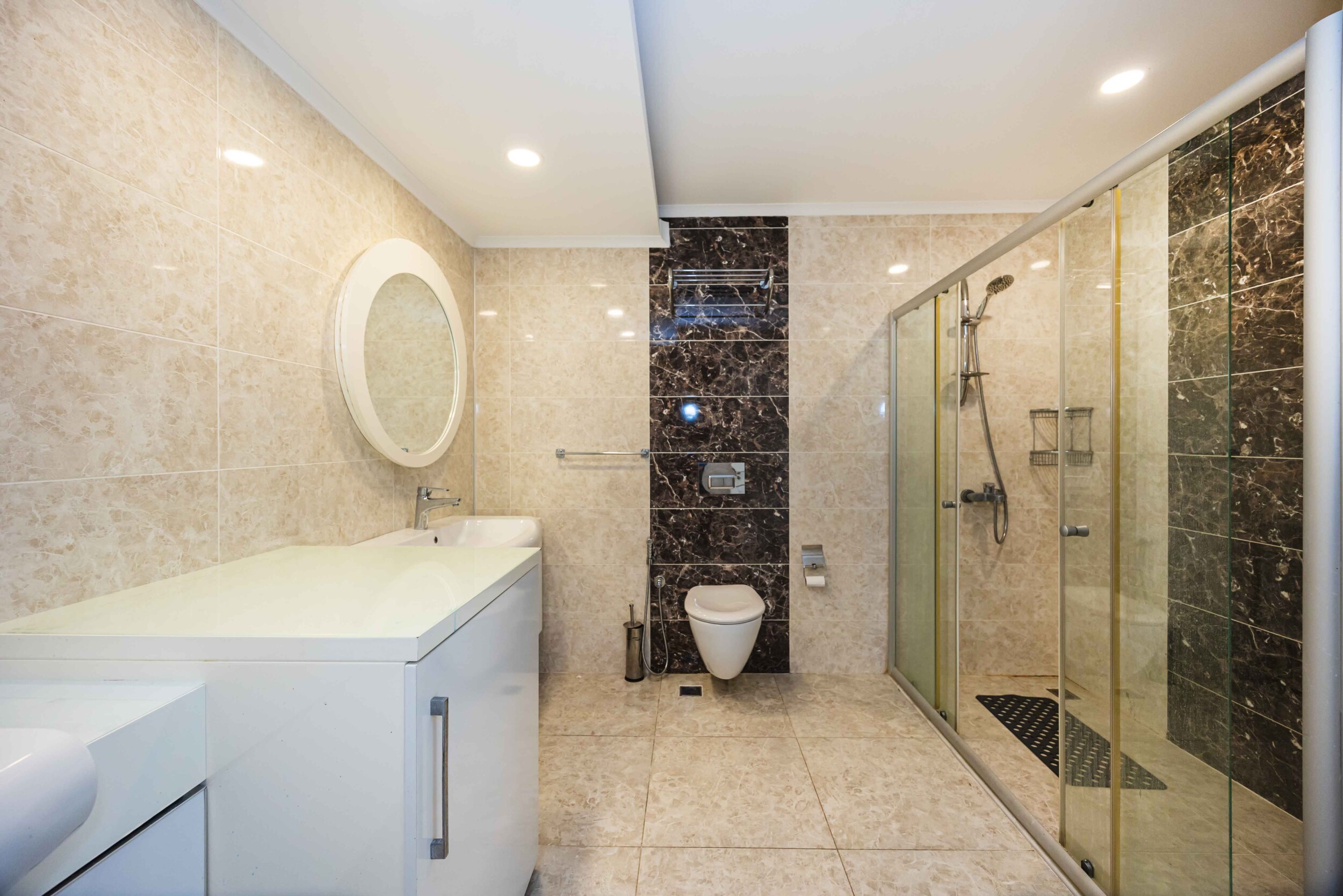 Bathroom with glass shower, wall-hung toilet and marble finishes in a villa