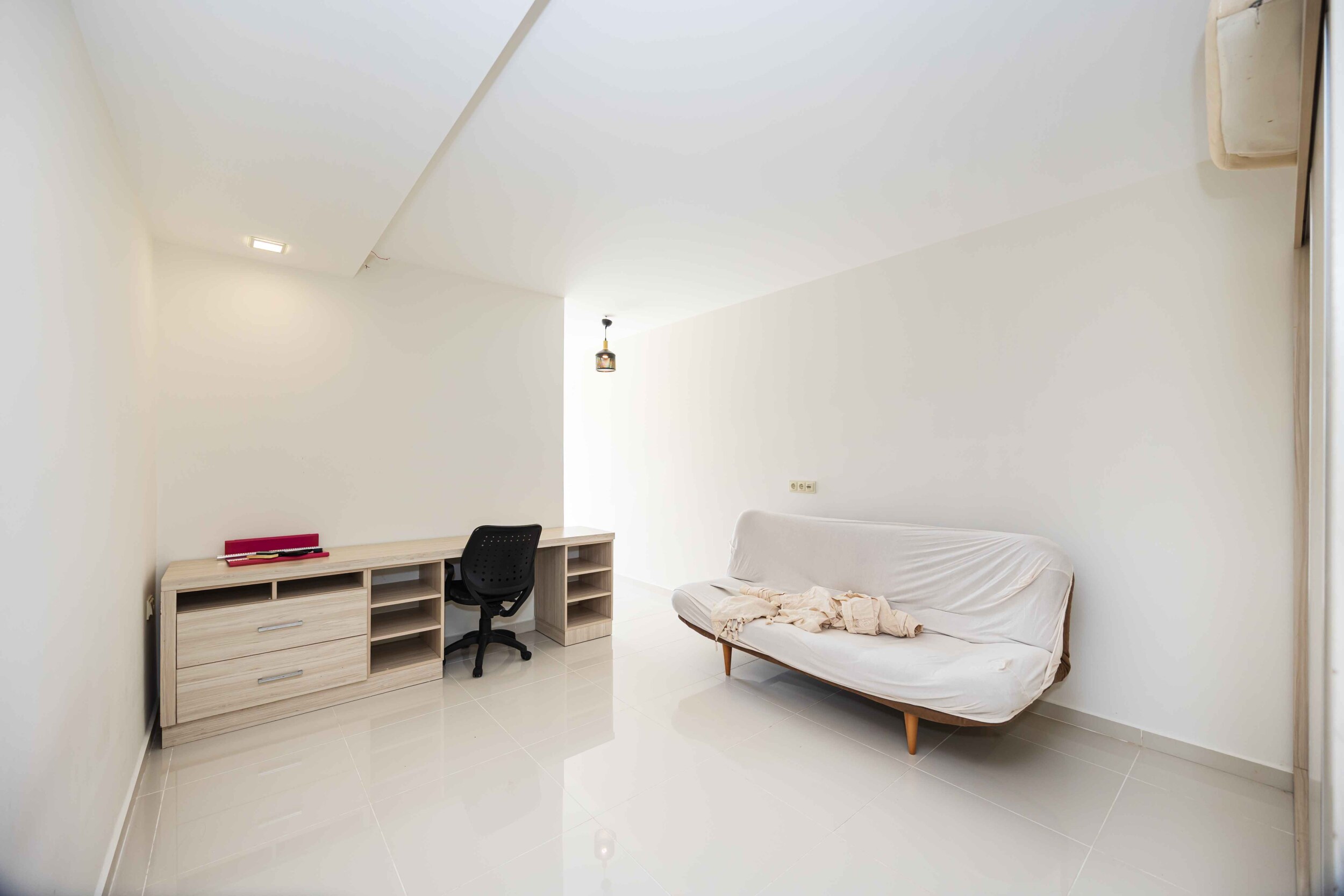 Living room with a white sofa, desk and open shelving in a house in Kargicak