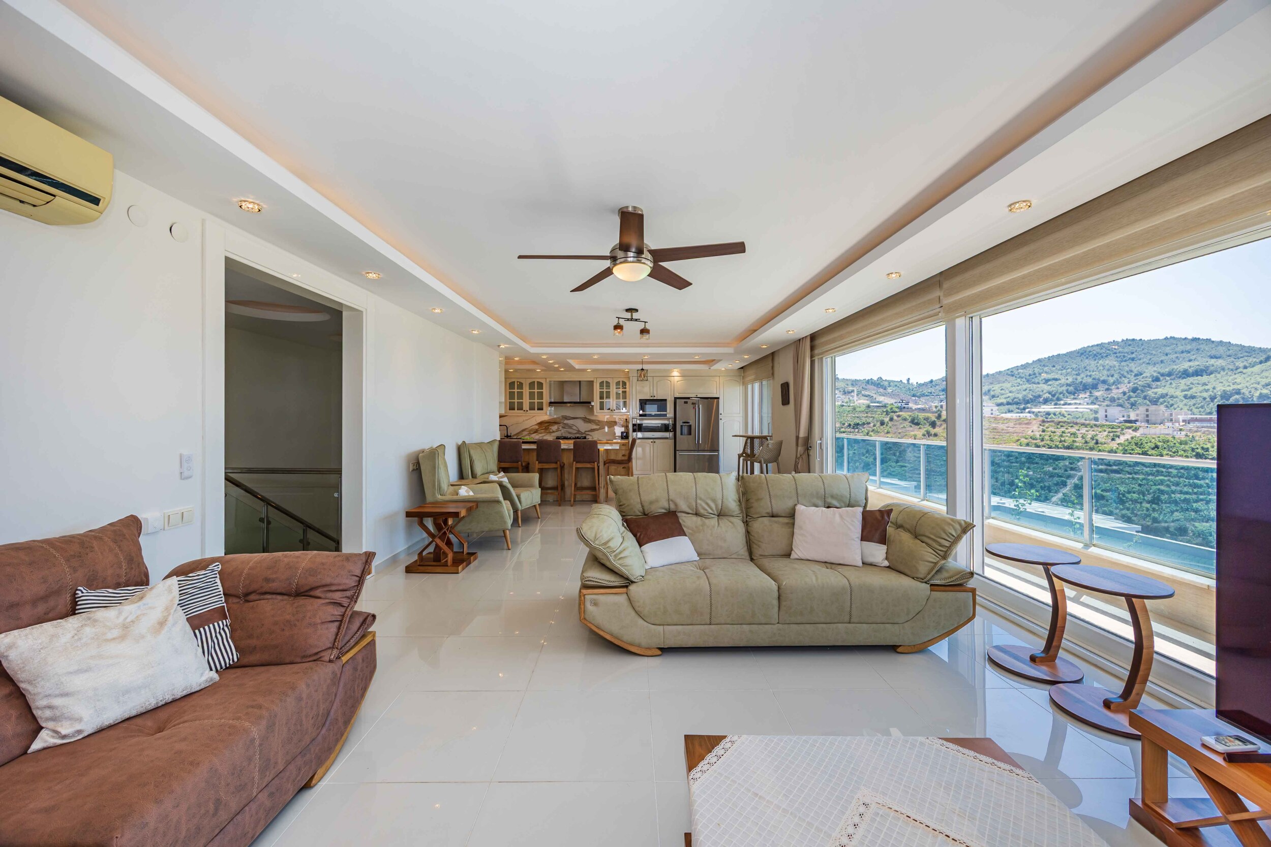 Living room with two sofas, television and kitchen area in a house in Kargicak for sale
