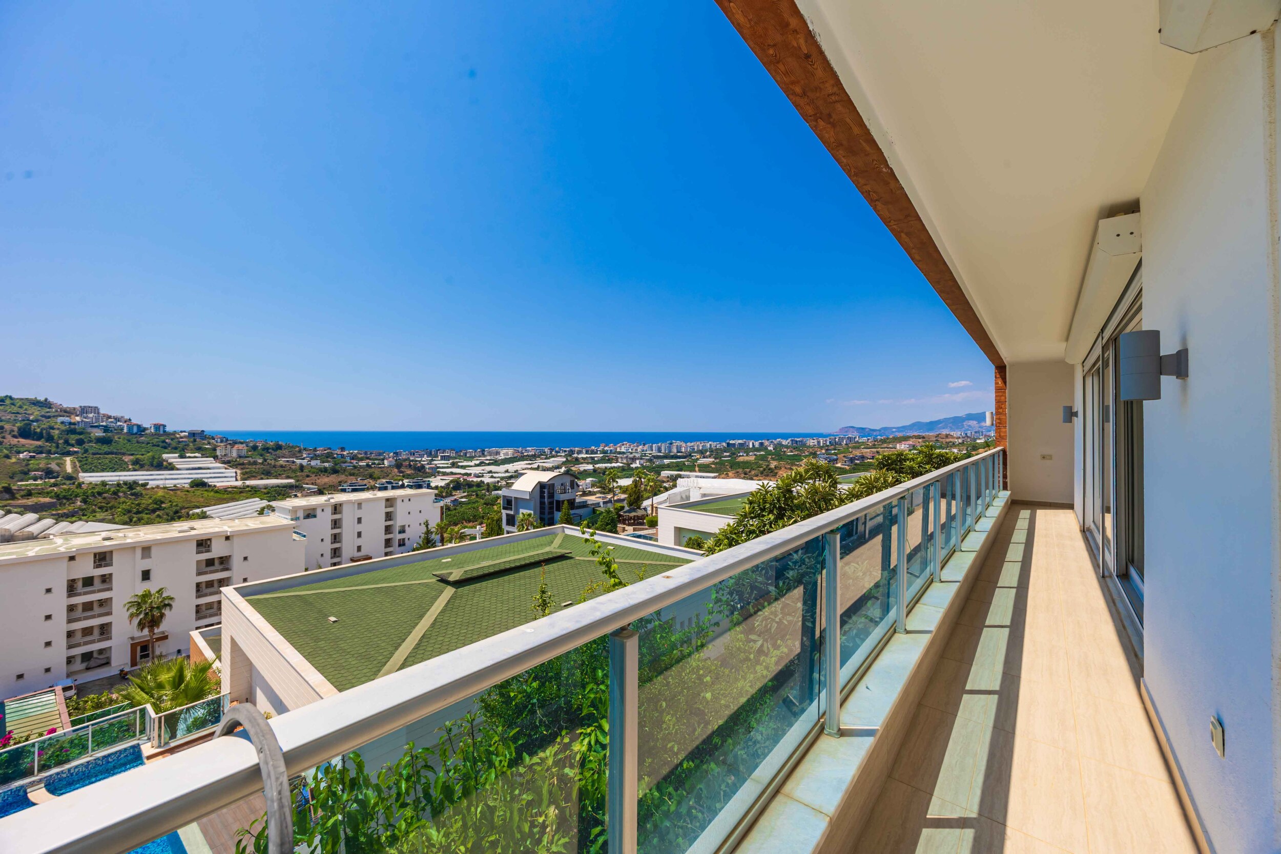 Long balcony with glass doors and sea views beside a villa in Turkey