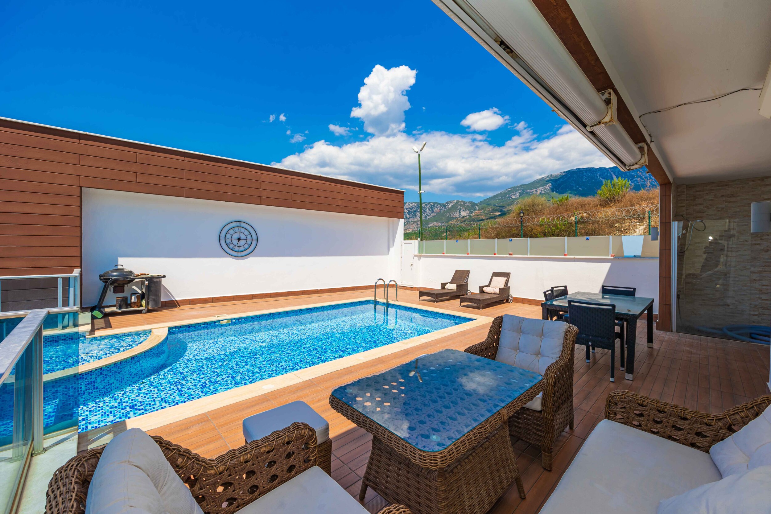 Mosaic pool, covered terrace and wicker furniture beside a villa in Kargicak