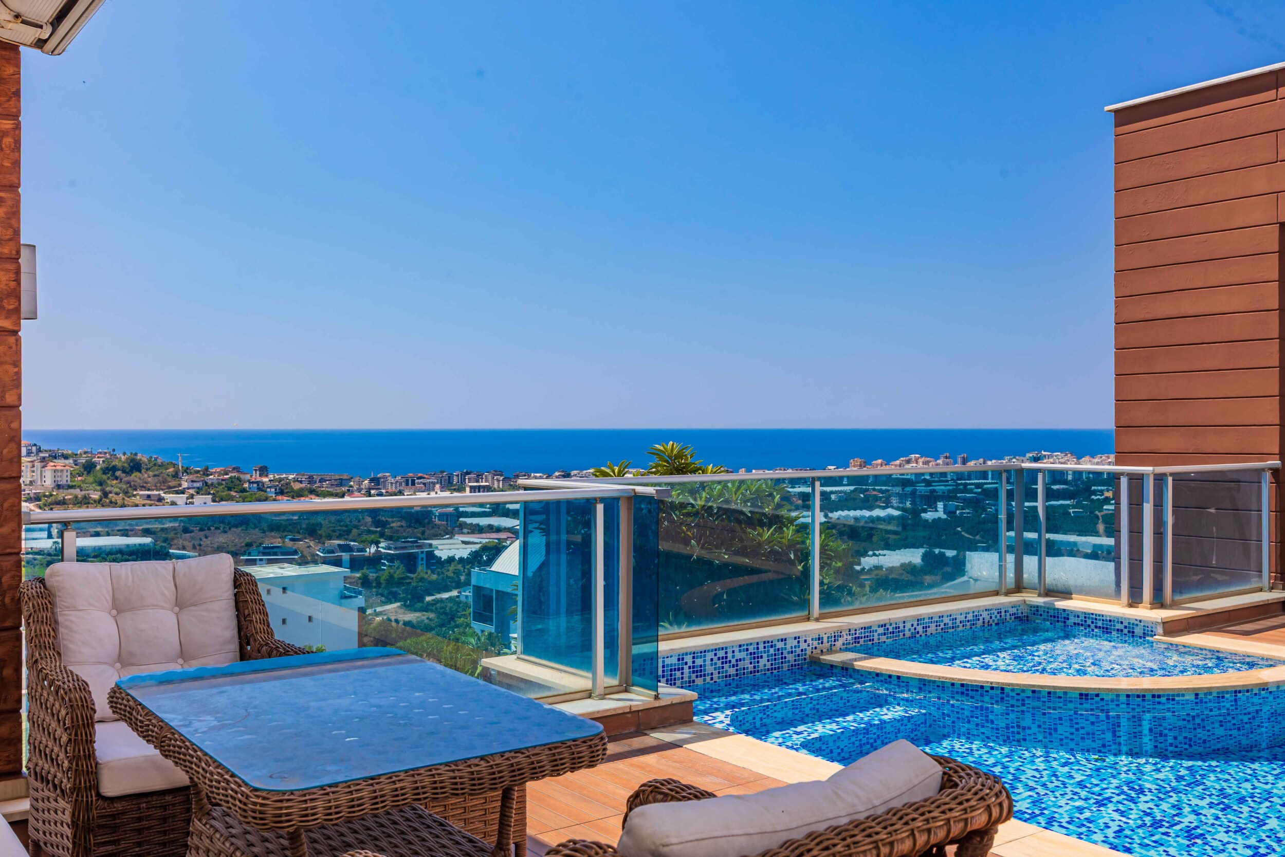Pool with round section and wooden terrace overlooking the sea in Kargicak for sale