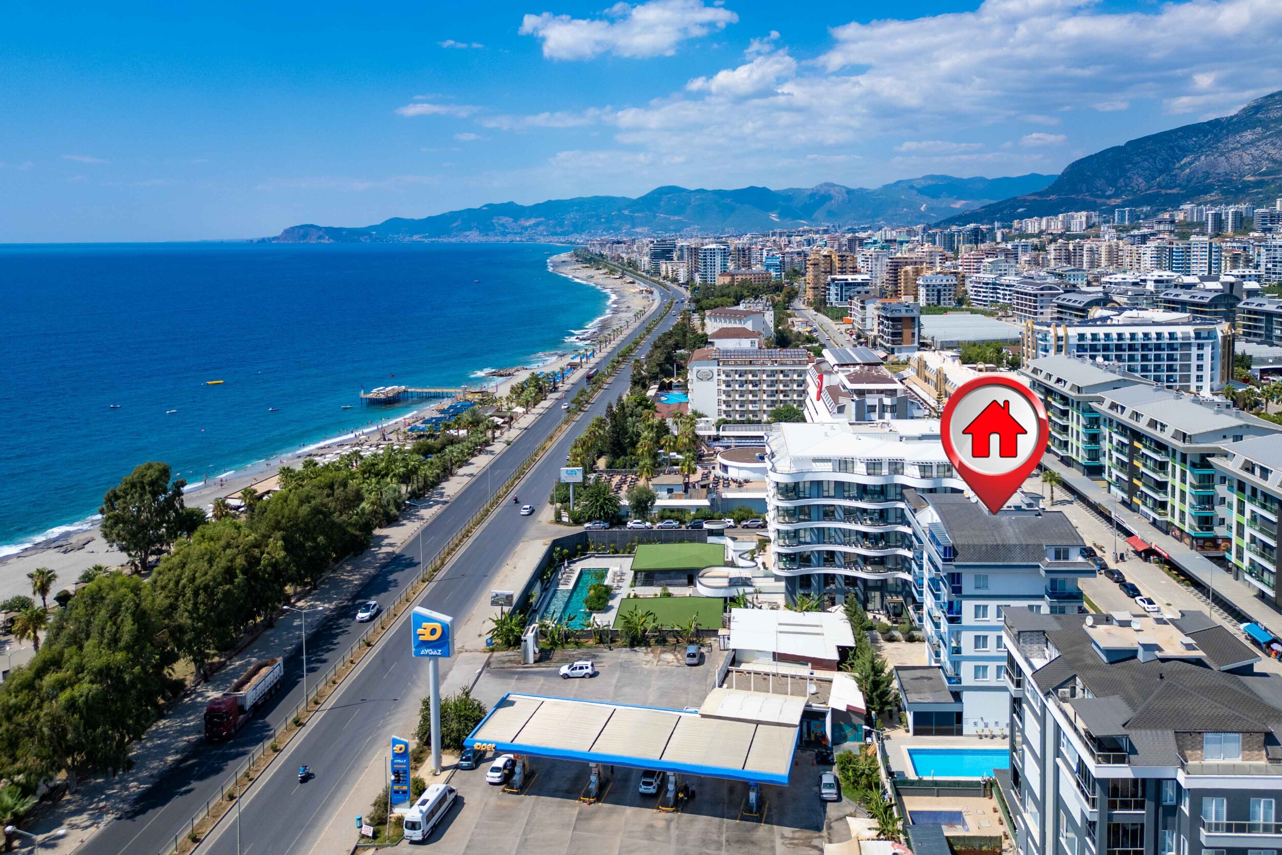 Coastal cityscape with a beach and pool at a complex with top-floor apartments near the sea in Turkey