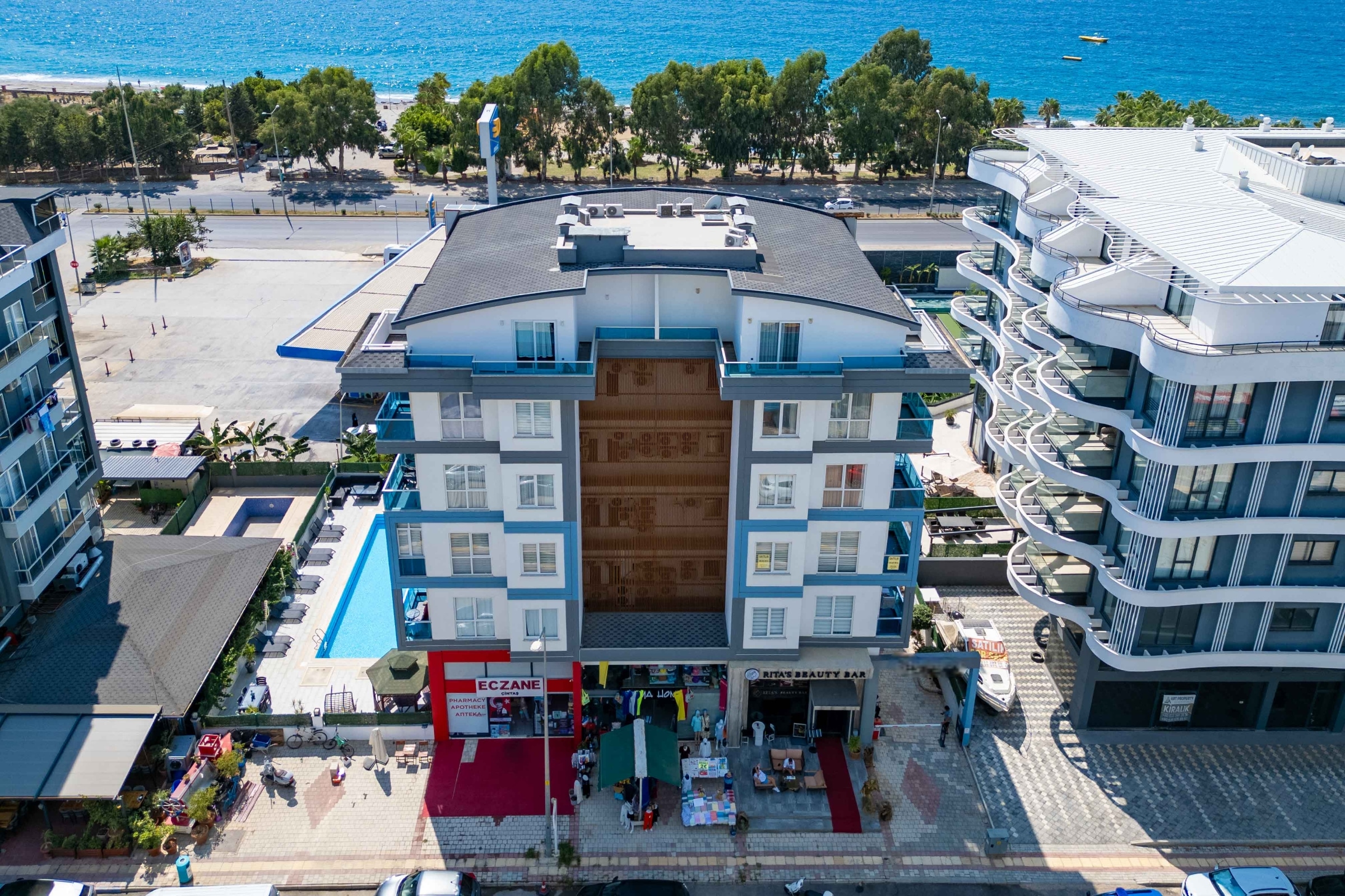 Residential facade with blue balconies and a pool showing a penthouse for sale in Turkey