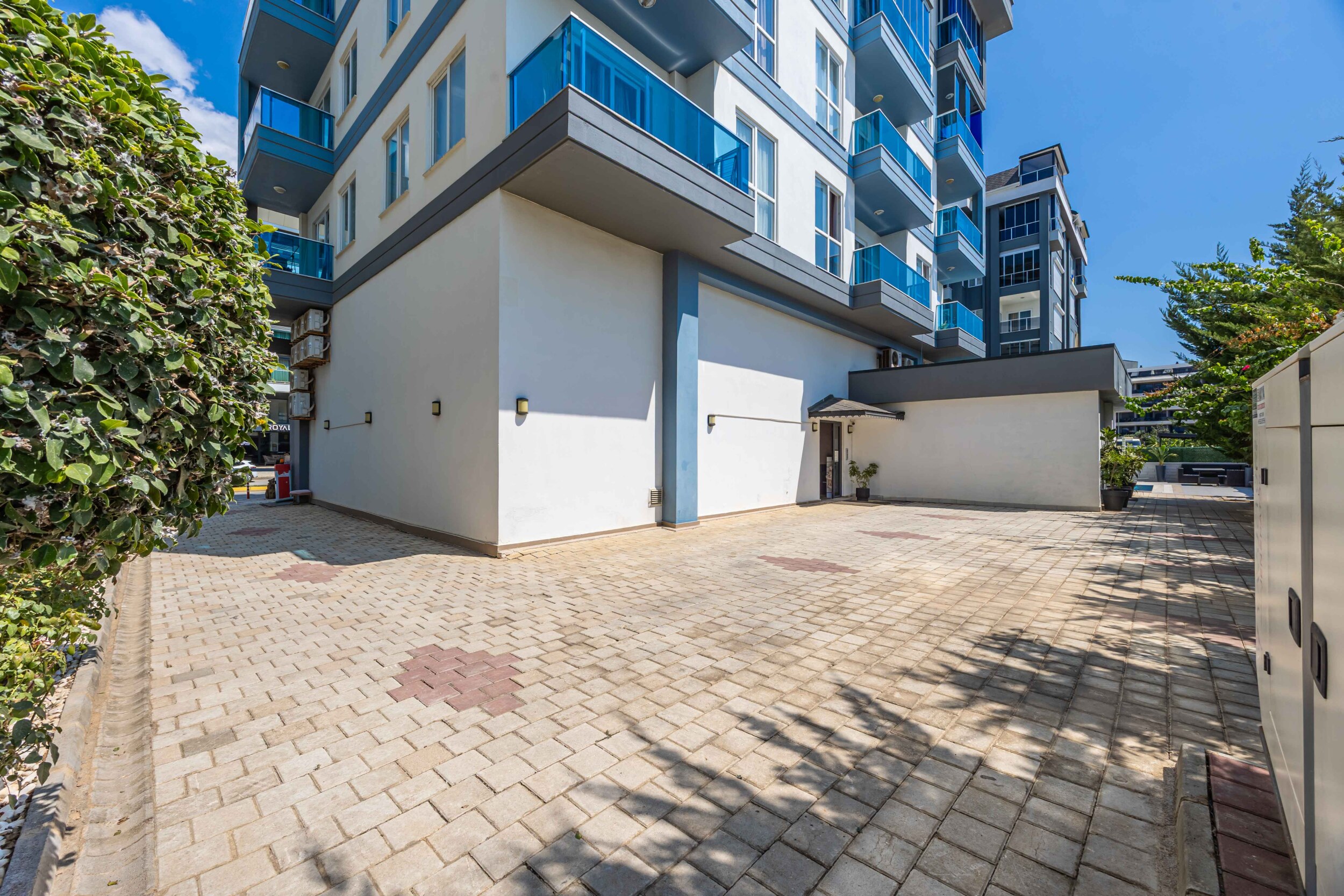 Paved courtyard and green hedge at a complex with penthouses in Turkey