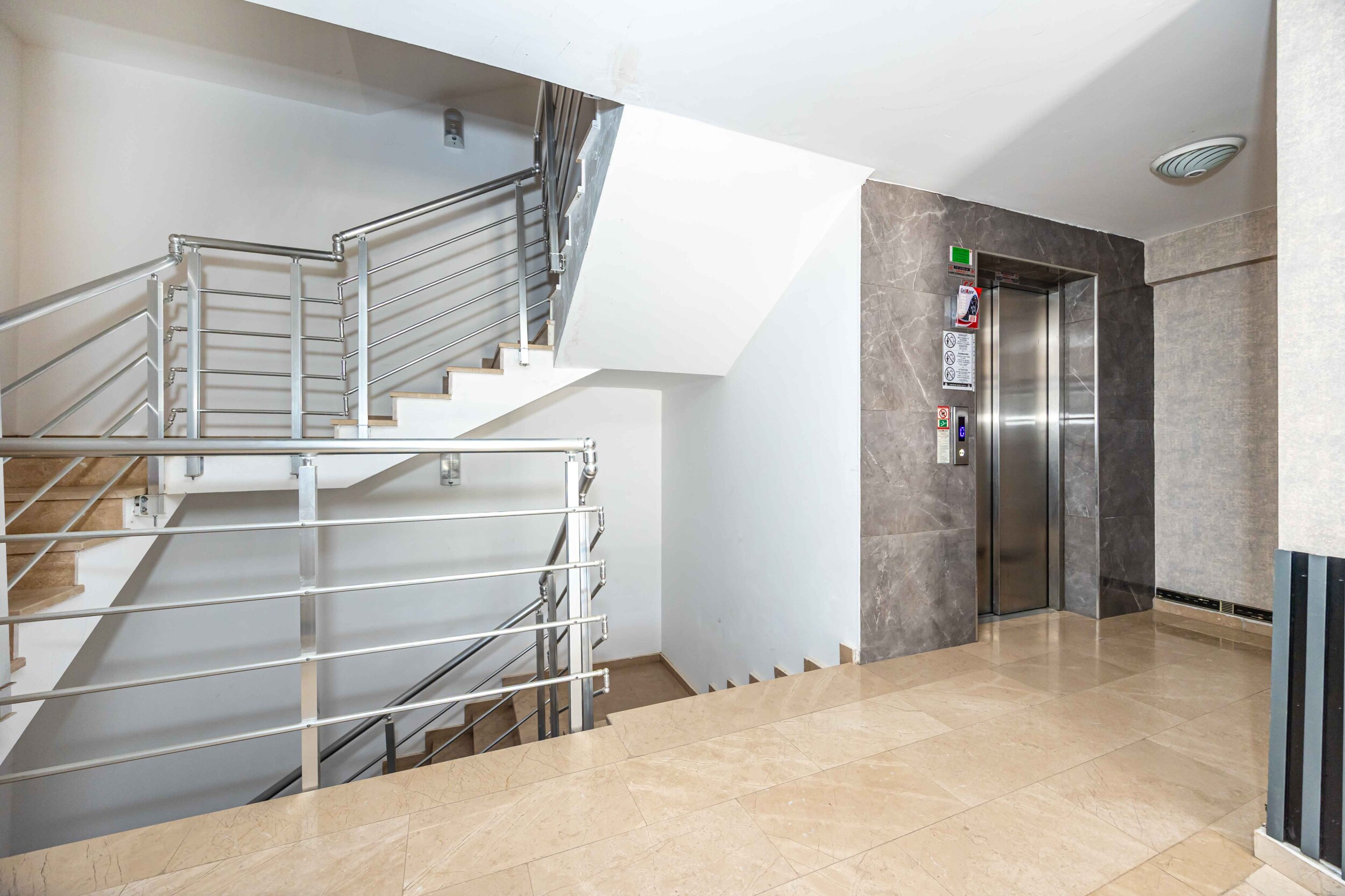 Stair landing with a lift and marble floor near a residence in Kargicak